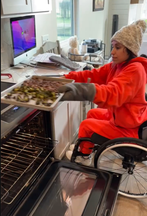 Maria Palen takes a tray of food out of the oven, as seen in a post dated January 8, 2025 | Source: Instagram/@planthlete_maria
