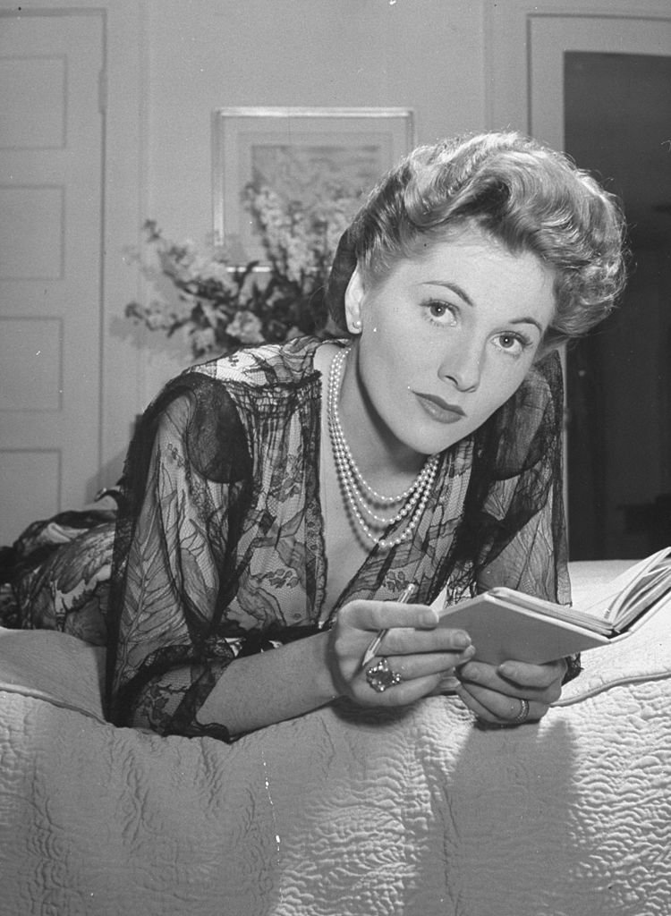 Actress Joan Fontaine wearing sheer negligee while lounging on bed at home. | Source: Getty Images