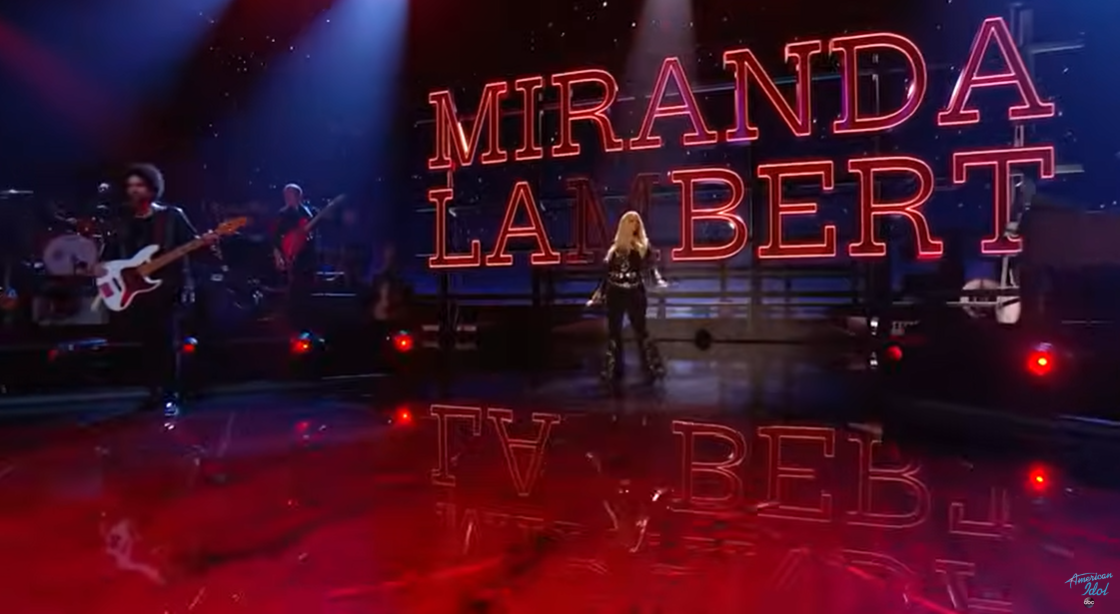 Miranda Lambert stands center stage with her name lit in bold red neon behind her, flanked by a live band during her May 4 performance of "Kerosene" | Source: YouTube/AmericanIdol