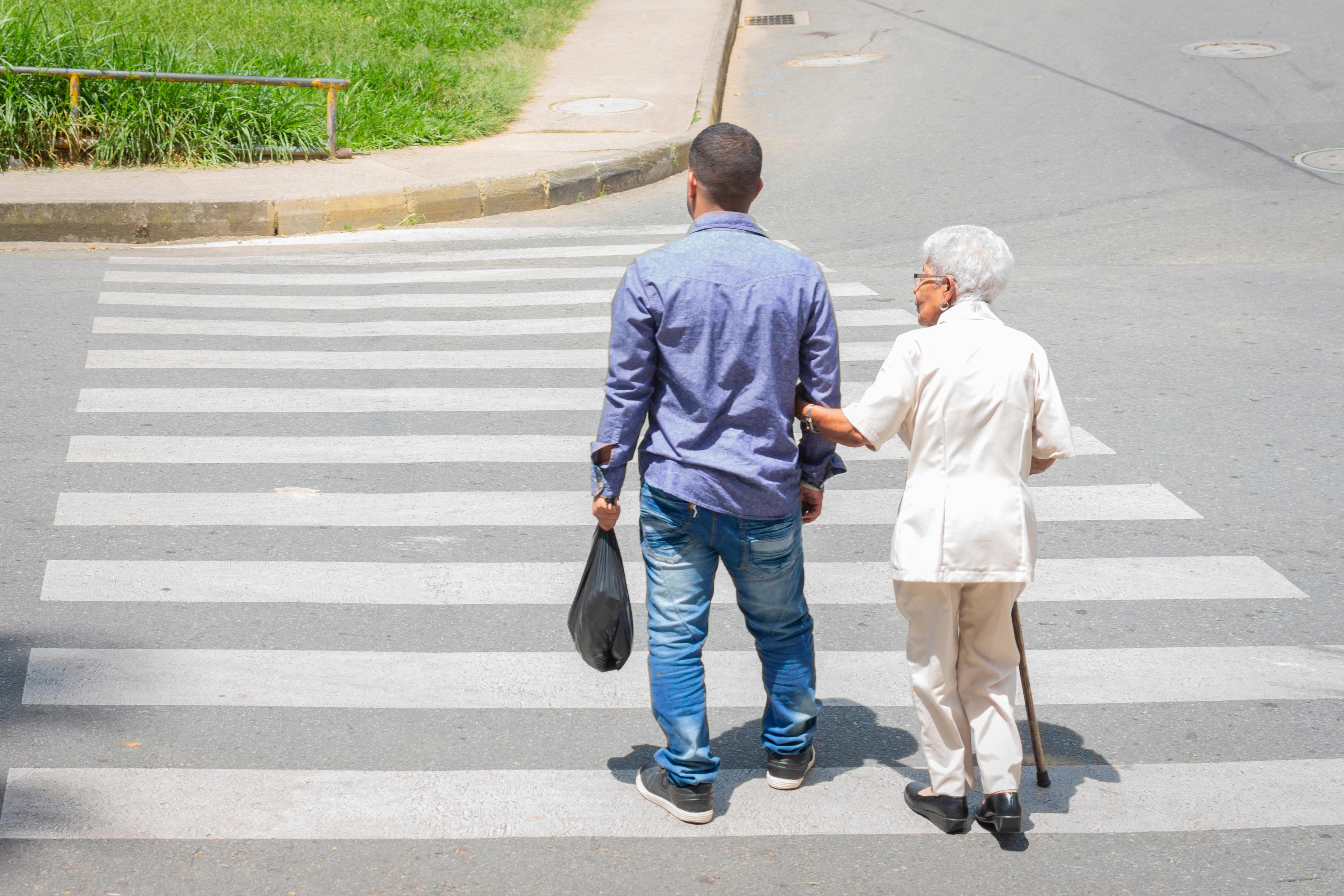 A man and an old woman crossing the street | Source: Shutterstock