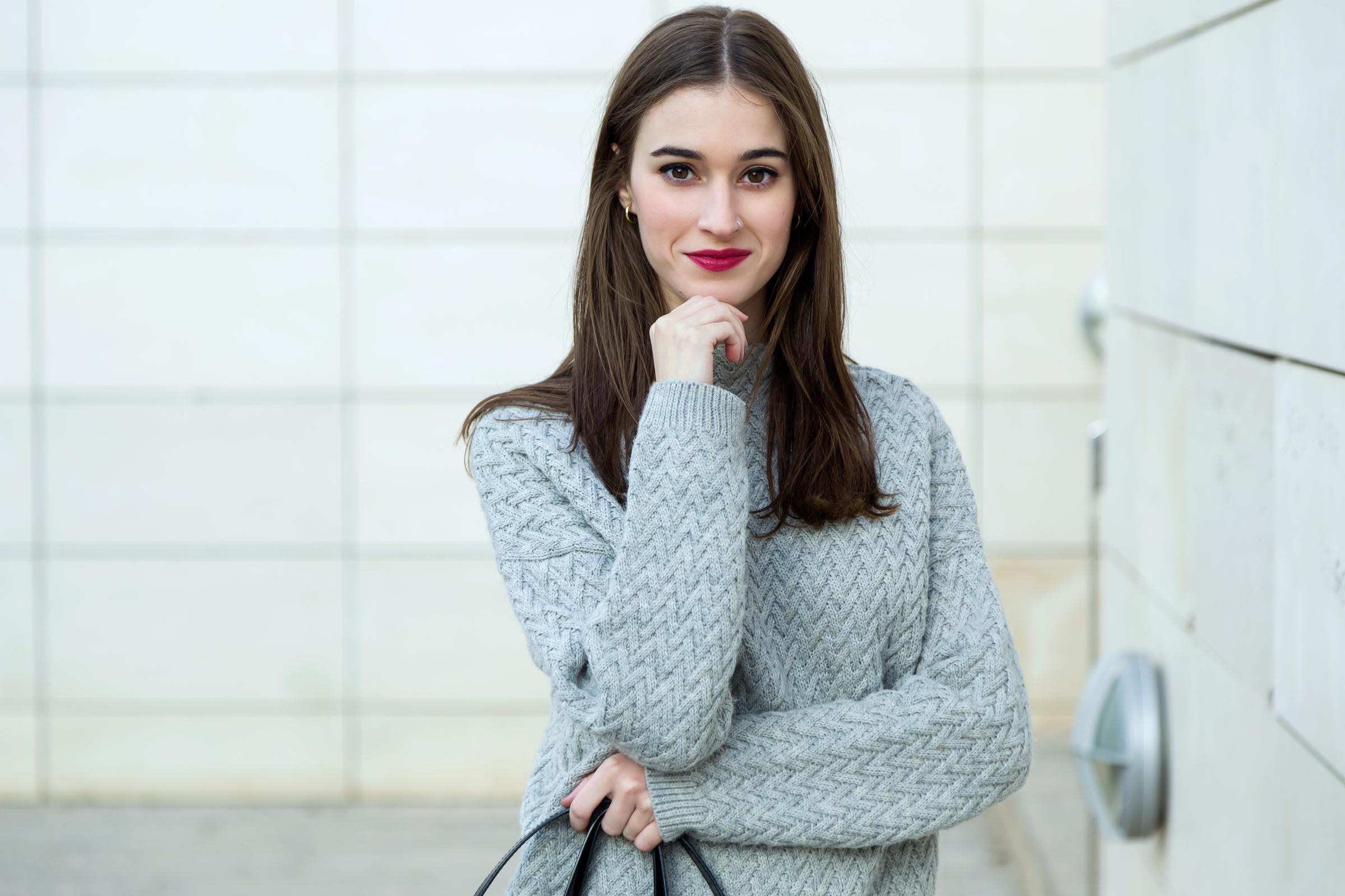 A confident-looking woman with her chin resting on one hand | Source: Freepik