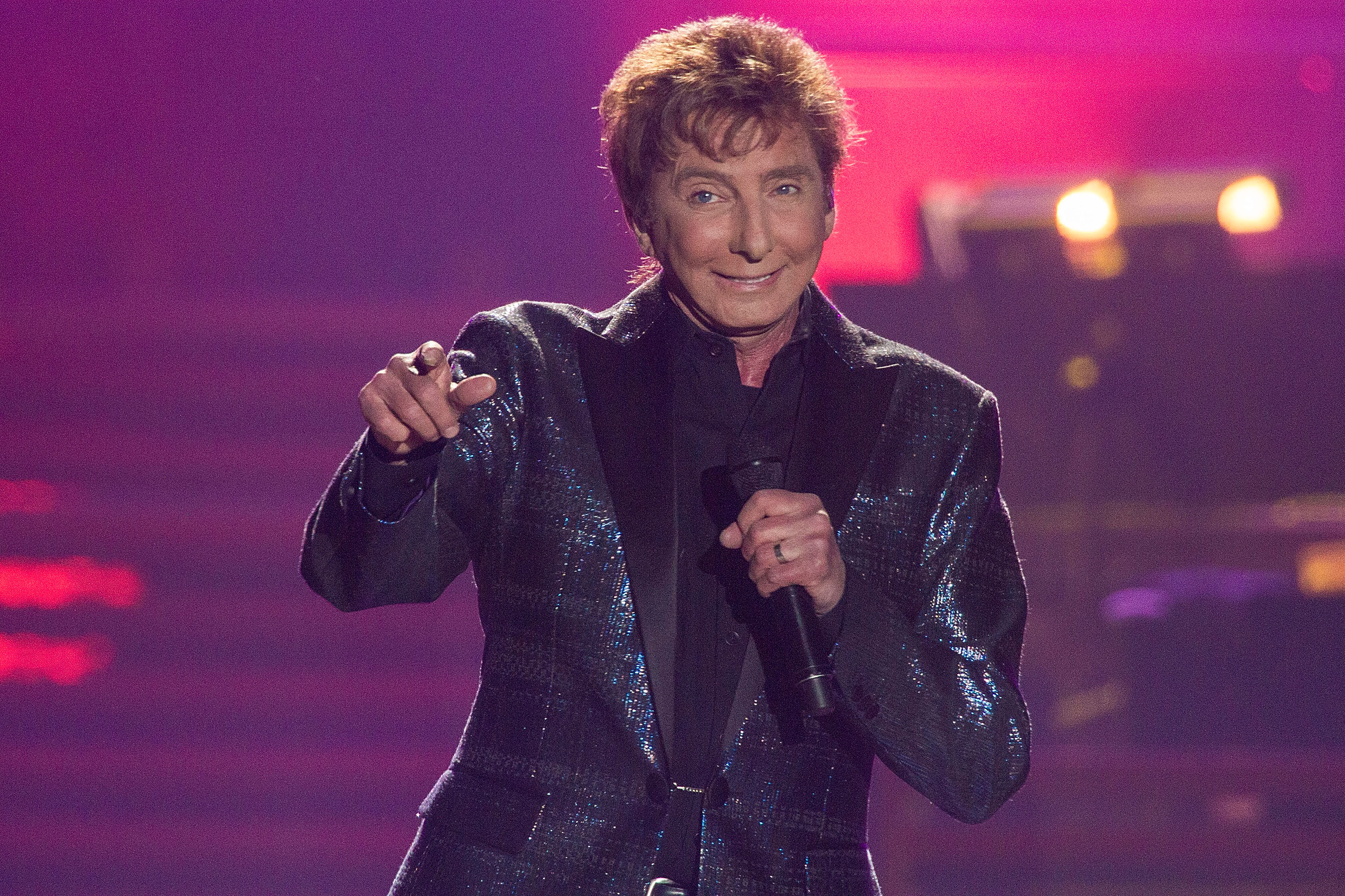 Manilow was still touring extensively in 2015, performing during his "One Last Time!" tour in San Diego. The image underscores how long he remained active onstage before the health problems that later forced him to postpone shows. | Source: Getty Images