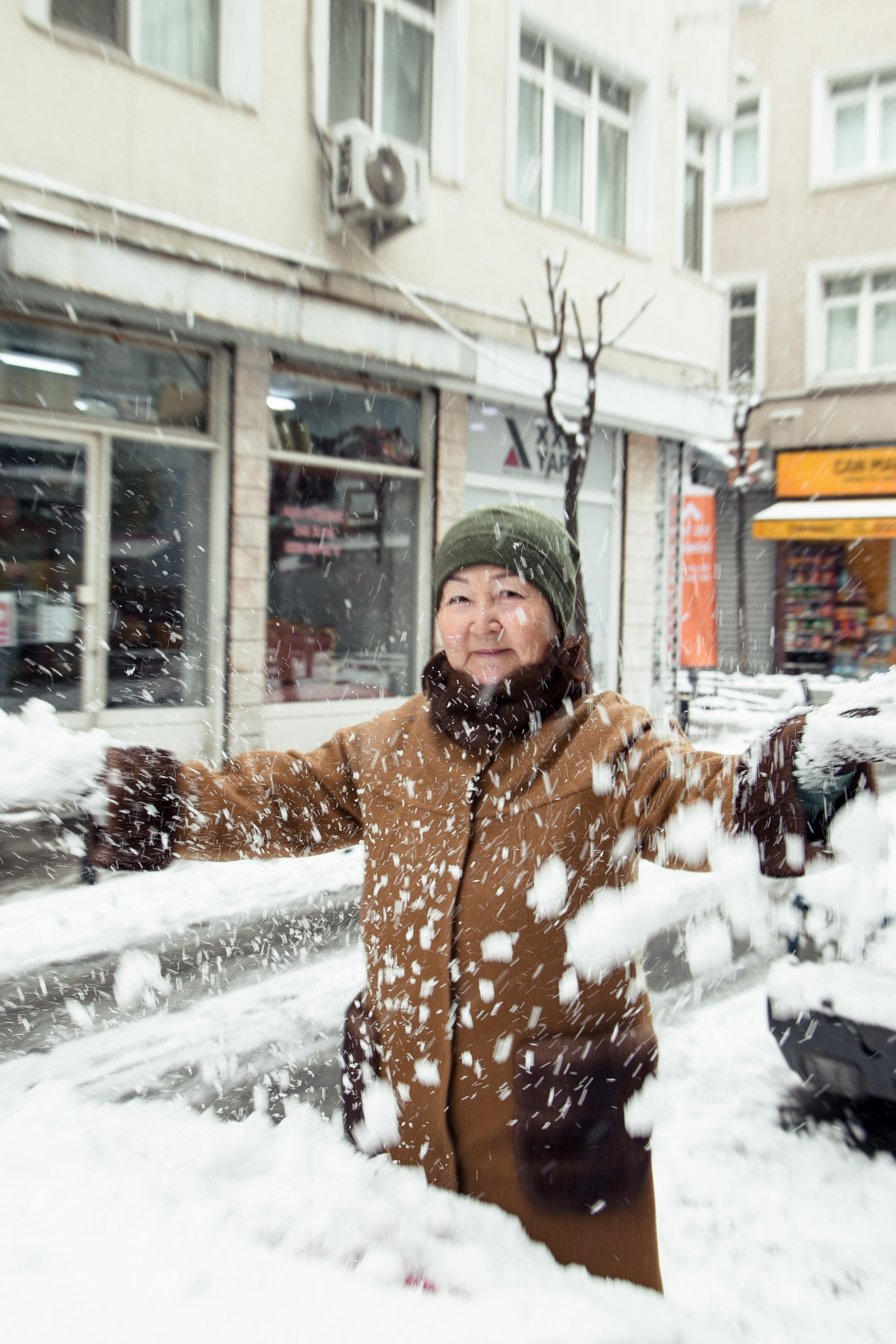 Pictured - A senior Asian woman throwing snow on the street daylight  | Source: Pexels 
