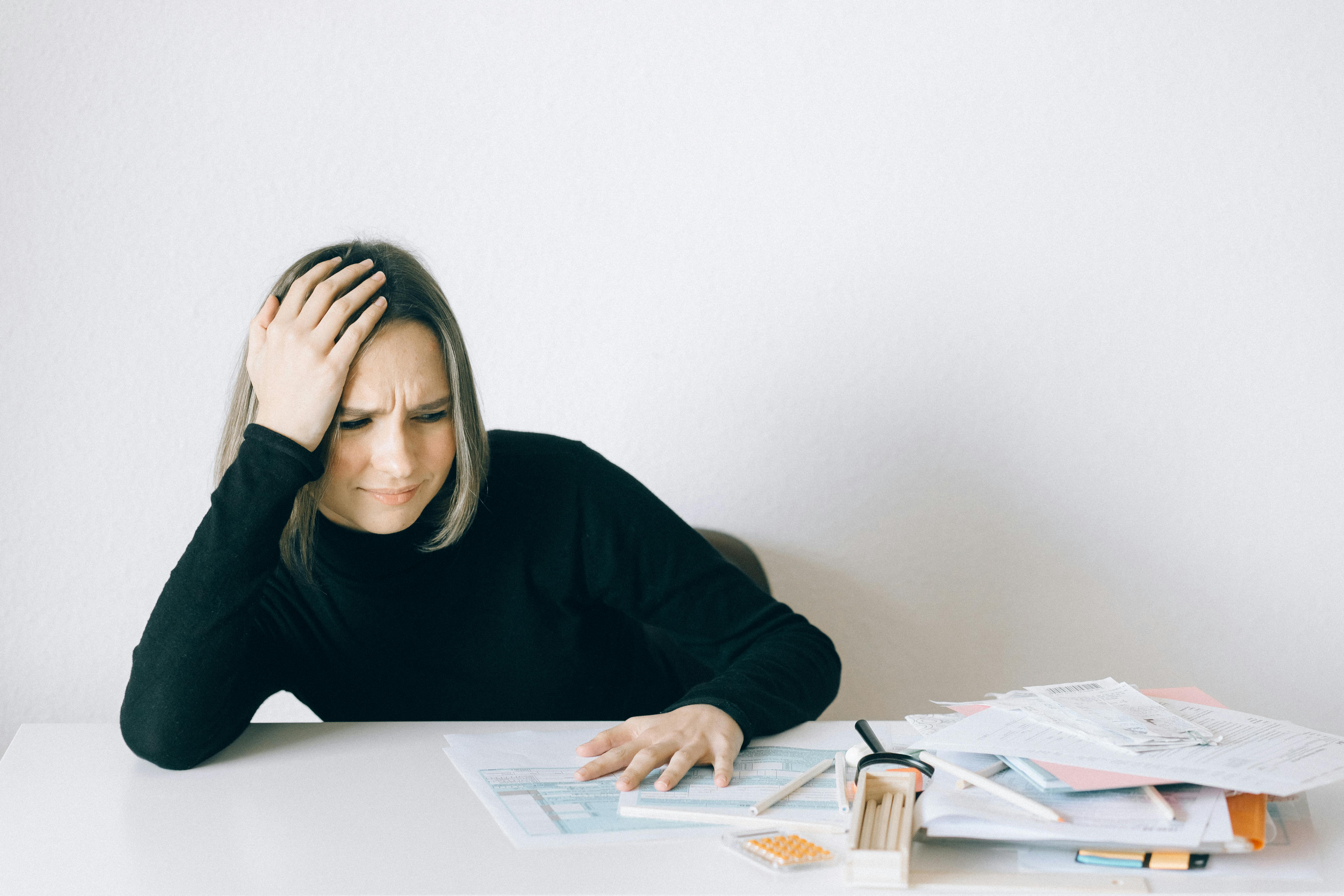 A stressed woman looking at bills | Source: Pexels