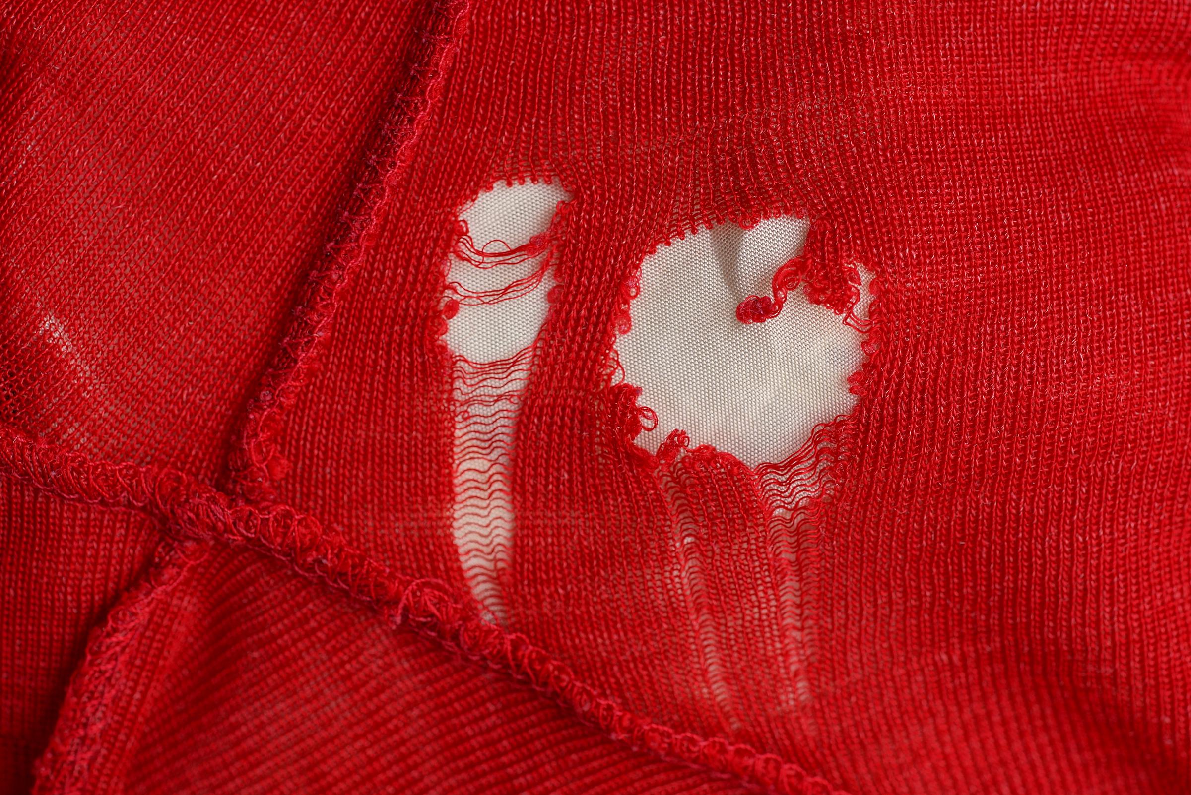 Holes on a red sweater | Source: Getty Images