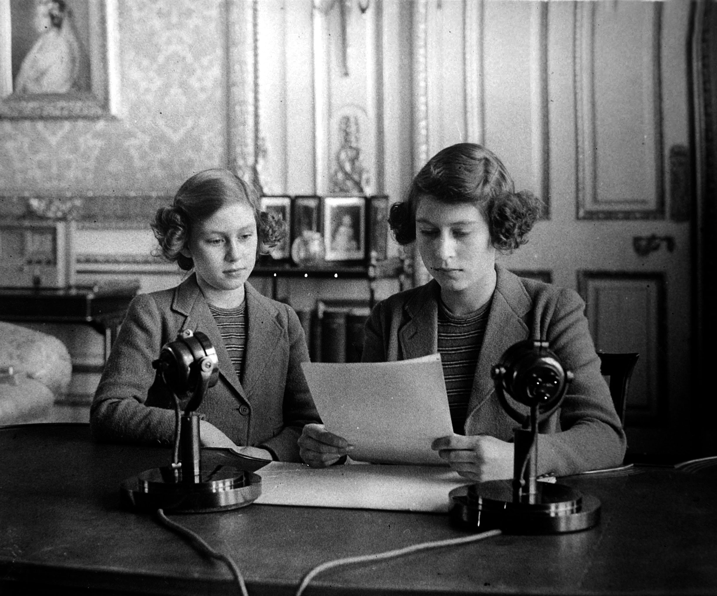 Princess Margaret (1930-2002), on left, and Princess Elizabeth give their first Children's Hour radio broadcast to the nation from Windsor Castle in Windsor, England during The Blitz and Battle of Britain in World War II on 13th October 1940. | Source: Getty Images