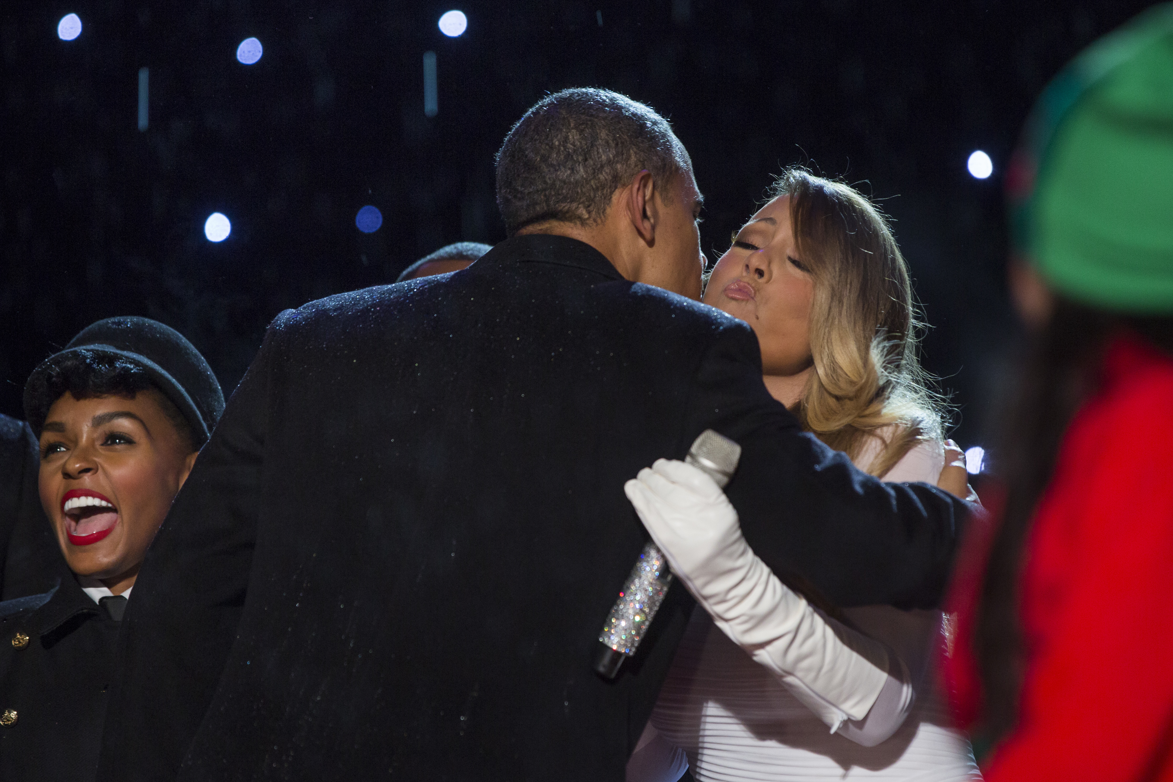 Barack Obama kisses Mariah Carey after she sang at the 91st National Christmas Tree Lighting Ceremony on the Ellipse, south of the White House, in Washington, DC, on December 6, 2013. | Source: Getty Images