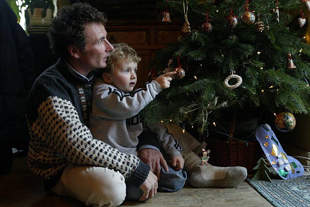 Un père et son fils devant le sapin de Noël | Photo : Getty Images