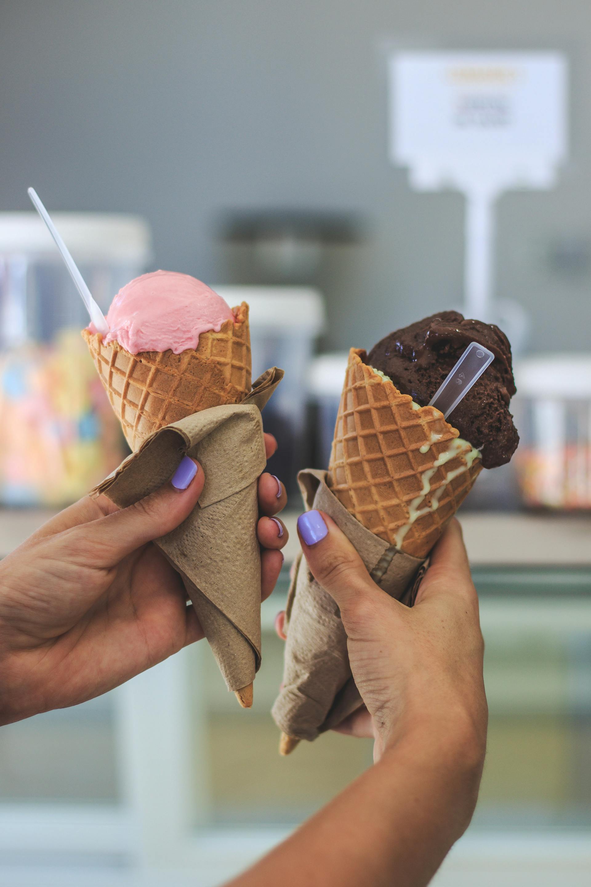 Close-up of a woman holding two ice cream cones | Source: Pexels