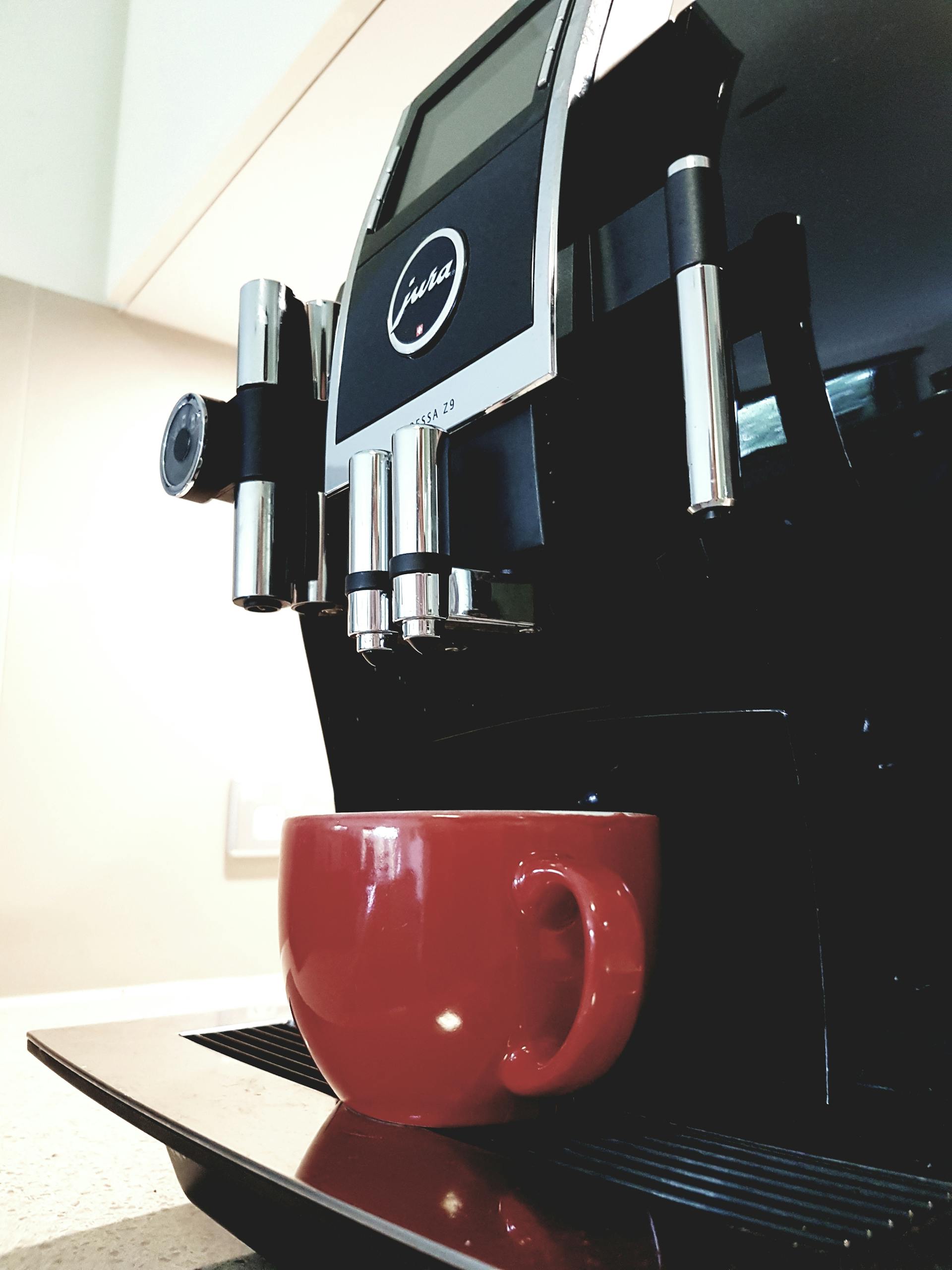 A coffee machine with a red cup | Source: Pexels