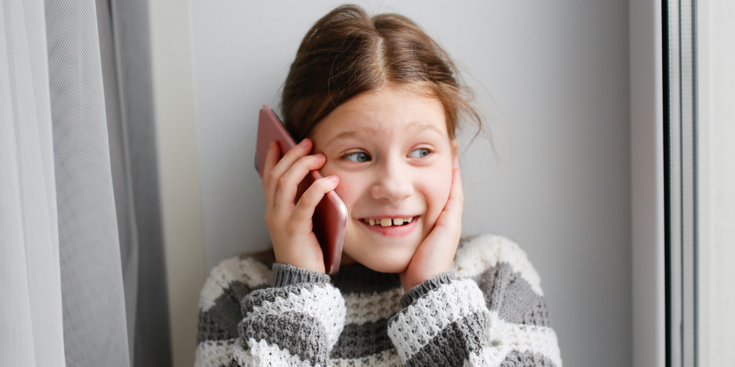 A young girl talking on phone | Source: Shutterstock