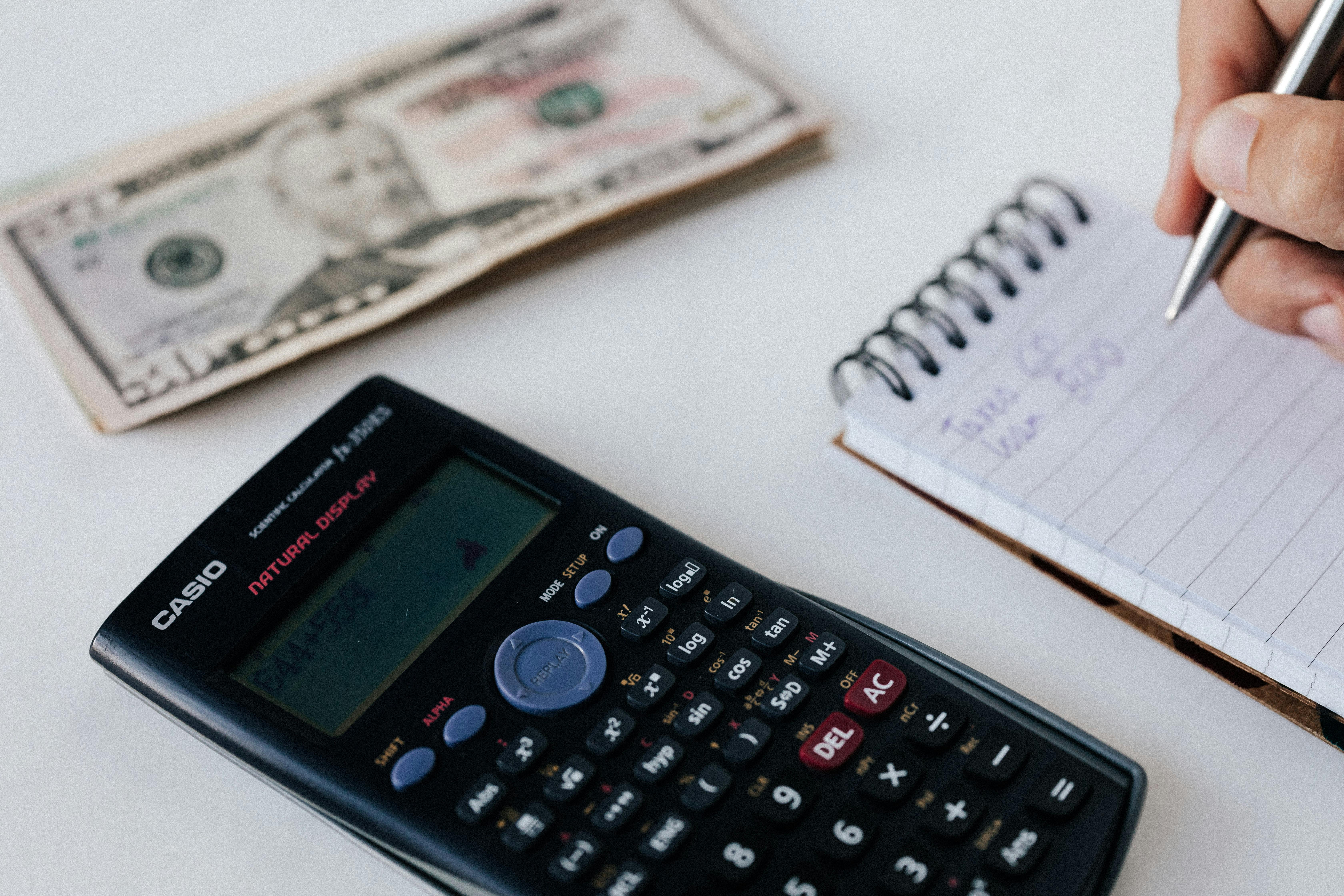 Someone making calculations while trying to save money | Source: Pexels