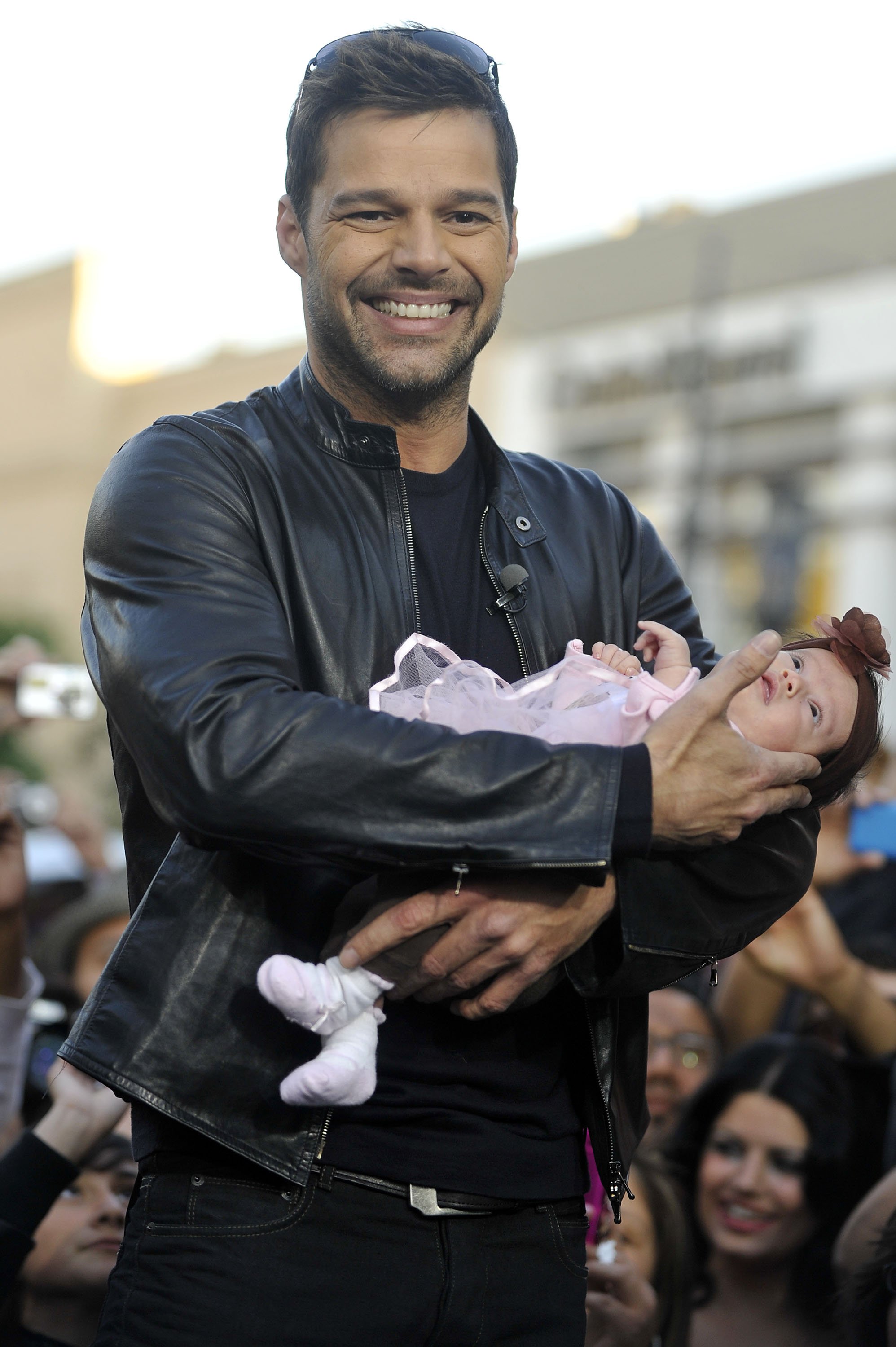 Ricky Martin cradles host Mario Lopez's daughter Gia Francesca on the set of the TV show "Extra" at The Grove on November 9, 2010, in Los Angeles, California. | Source: Getty Images