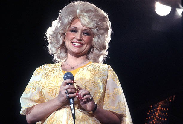 Country singer Dolly Parton performs onstage wearing a yellow dress, in 1975, Los Angeles, California | Source: Michael Ochs Archives/Getty Images