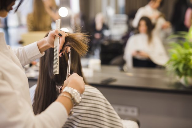 Mujer cortándose el pelo. | Foto: Freepik