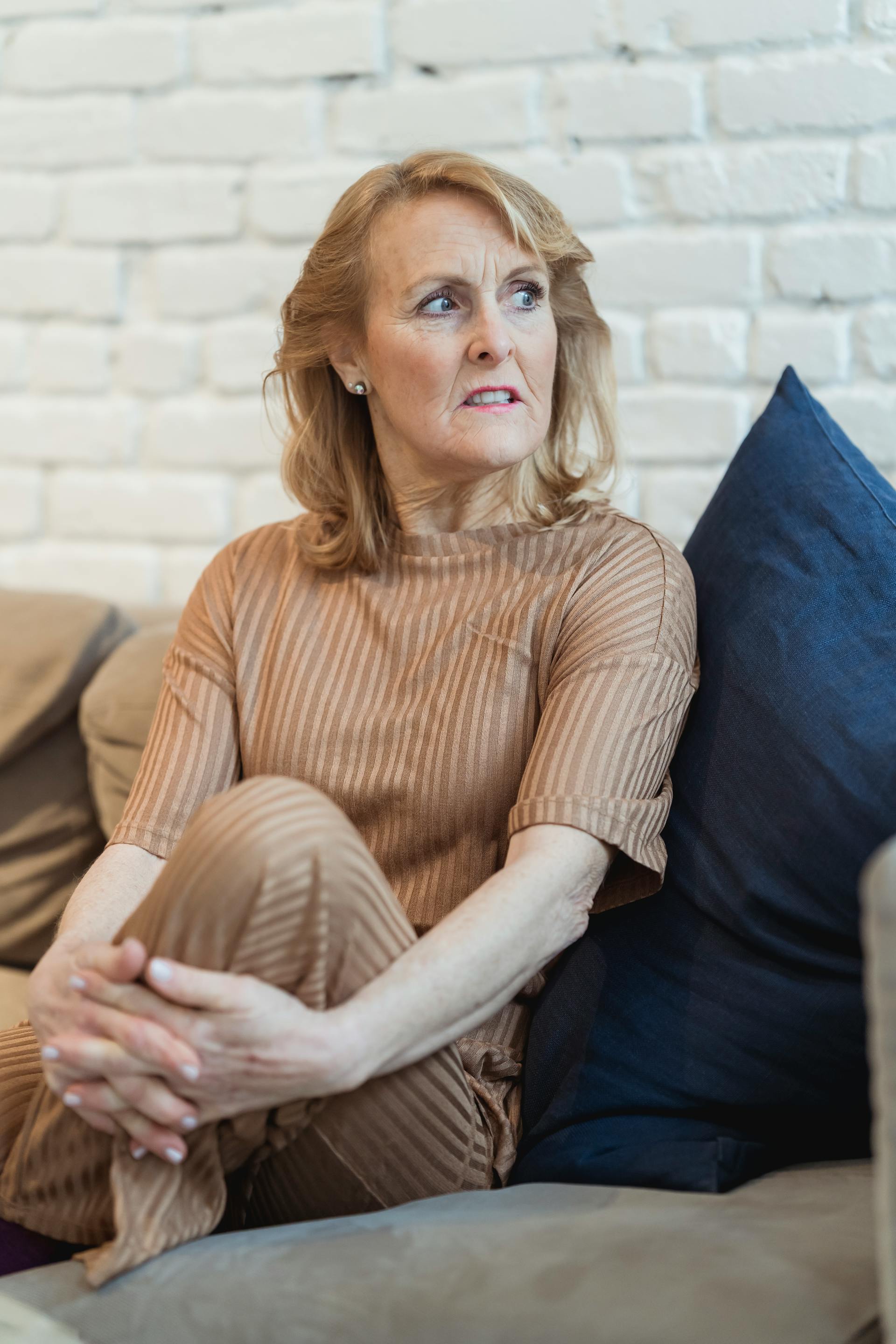 An angry senior woman sitting on the sofa | Source: Pexels