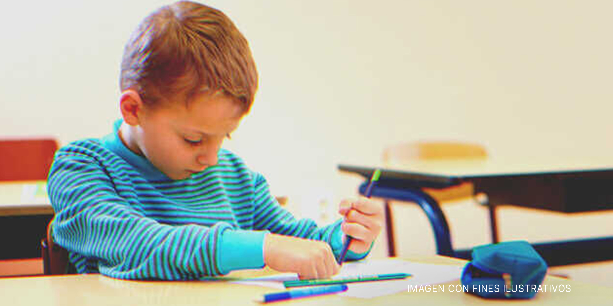 Niño escribiendo sentado frente a una mesa. | Foto: Shutterstock