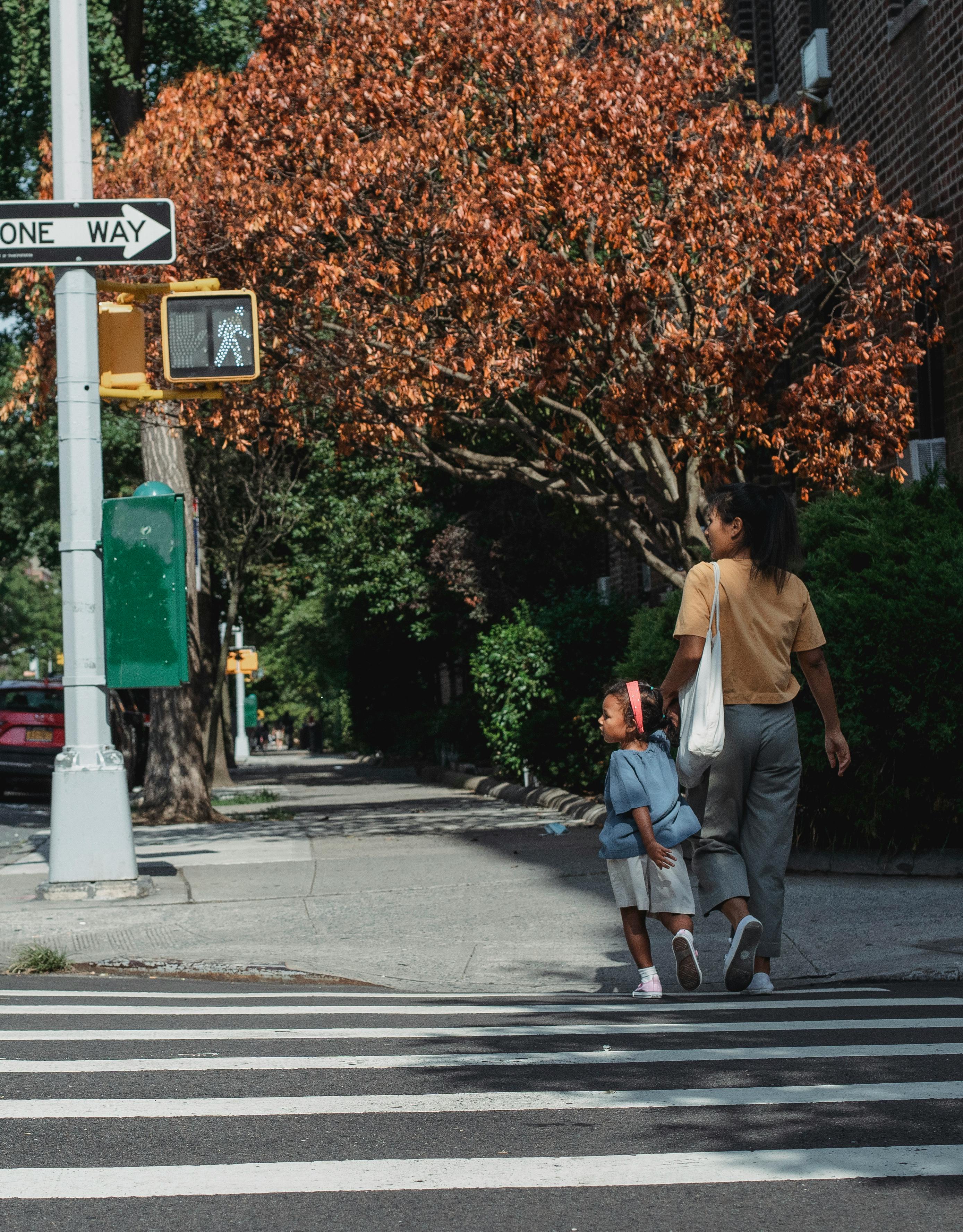 A woman and young girl crossing a road | Source: Pexels