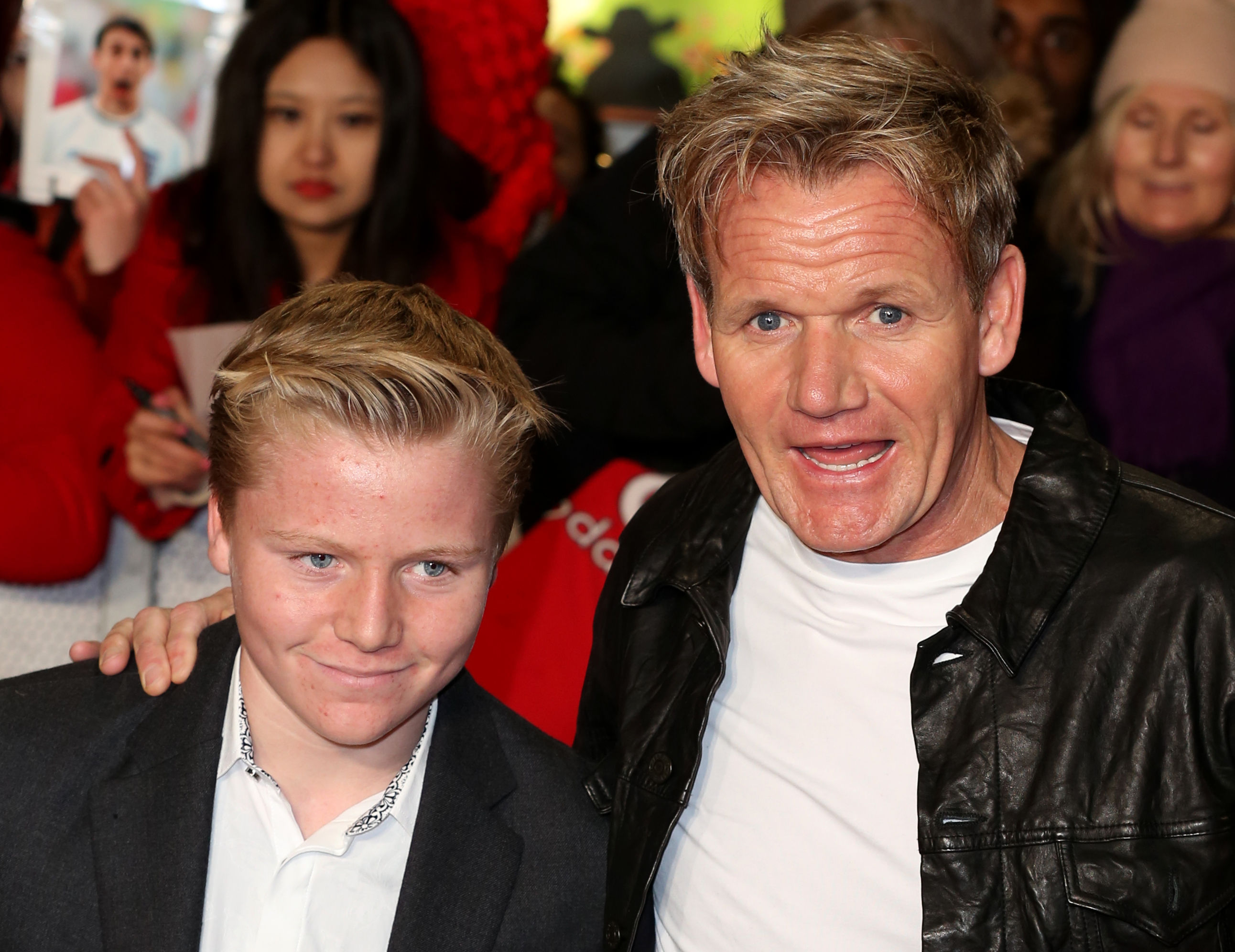 Gordon Ramsay with his arm around a teenage Jack at the "Class of 92" world premiere at the Odeon Leicester Square — Jack in a black blazer with slicked blond hair, the same wide eyes and jaw as his father clearly visible.