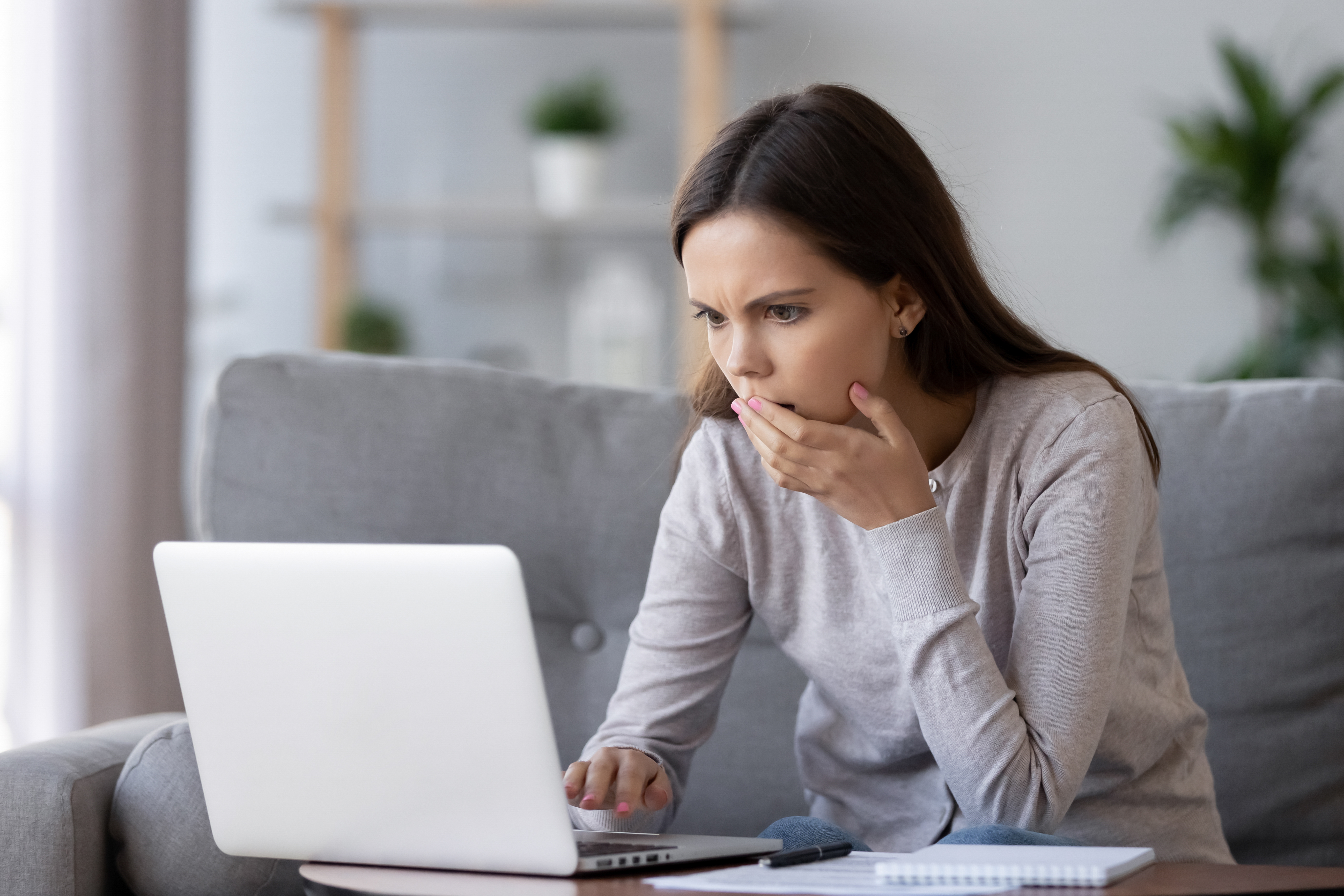 A woman shocked after seeing something on her laptop | Source: Shutterstock