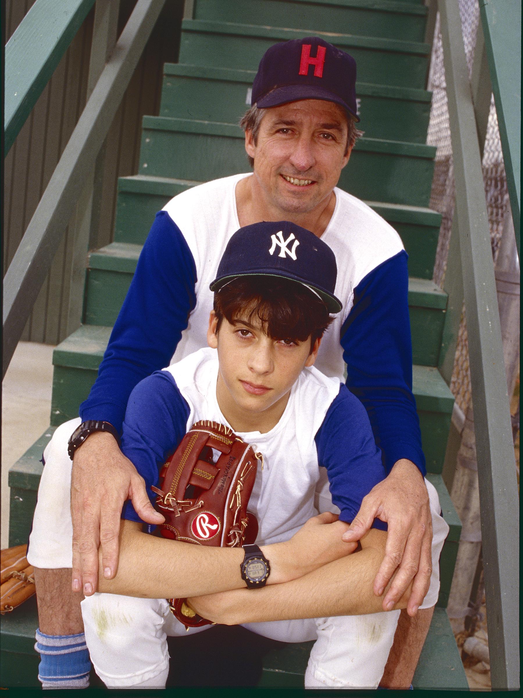 Tom Hayden and his son Troy pose together in baseball uniforms at Babe Ruth Field in Culver City, California, February 7, 1987 | Source: Getty Images