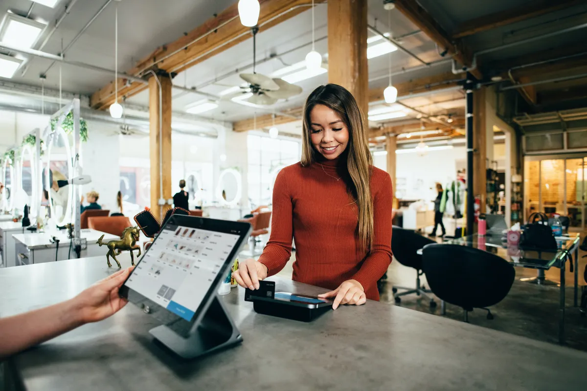 Une femme payant à la caisse d'un magasin | Photo : Unsplash