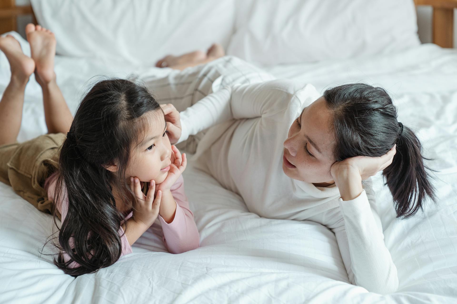 A woman talking to her daughter on the bed | Source: Pexels