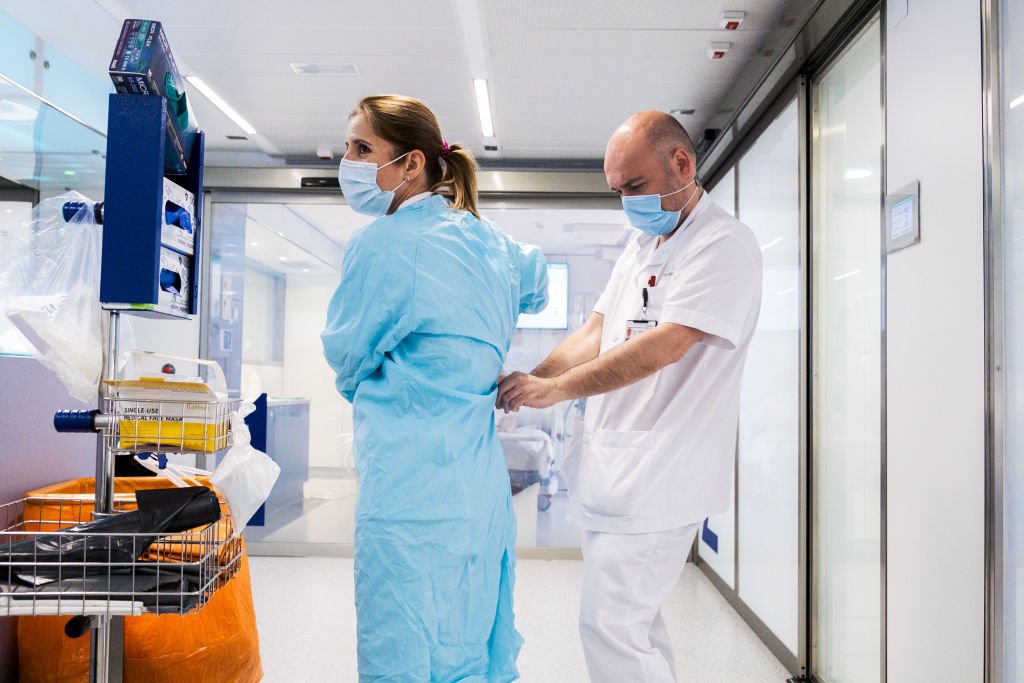 La enfermera Cristina González Pasarín recibe ayuda para usar equipo de protección como precaución durante la pandemia por el COVID-19. | Foto: Getty Images