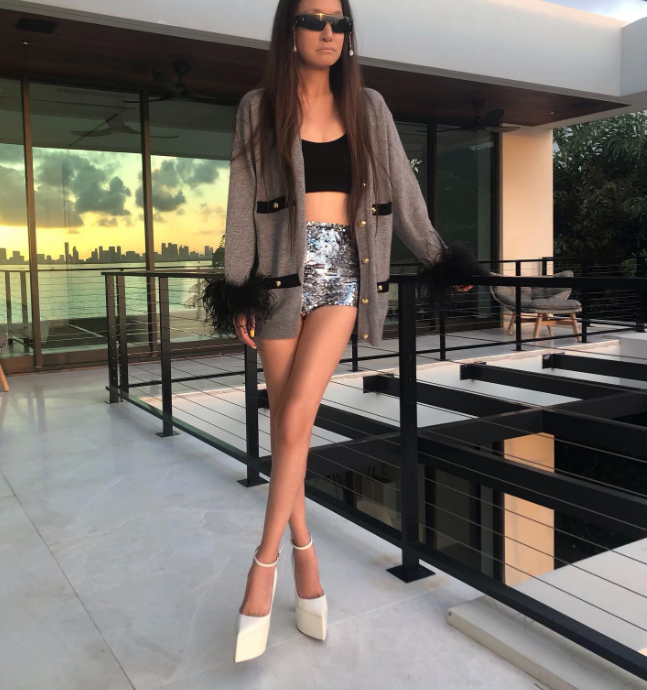 Her styling outside of red carpets was also very quirky, sexy, and daring. In this photo, Vera Wang posed at her home in short shorts, a crop top, a funky jacket, and sunglasses on January 10, 2023. | Source: Instagram/verawang