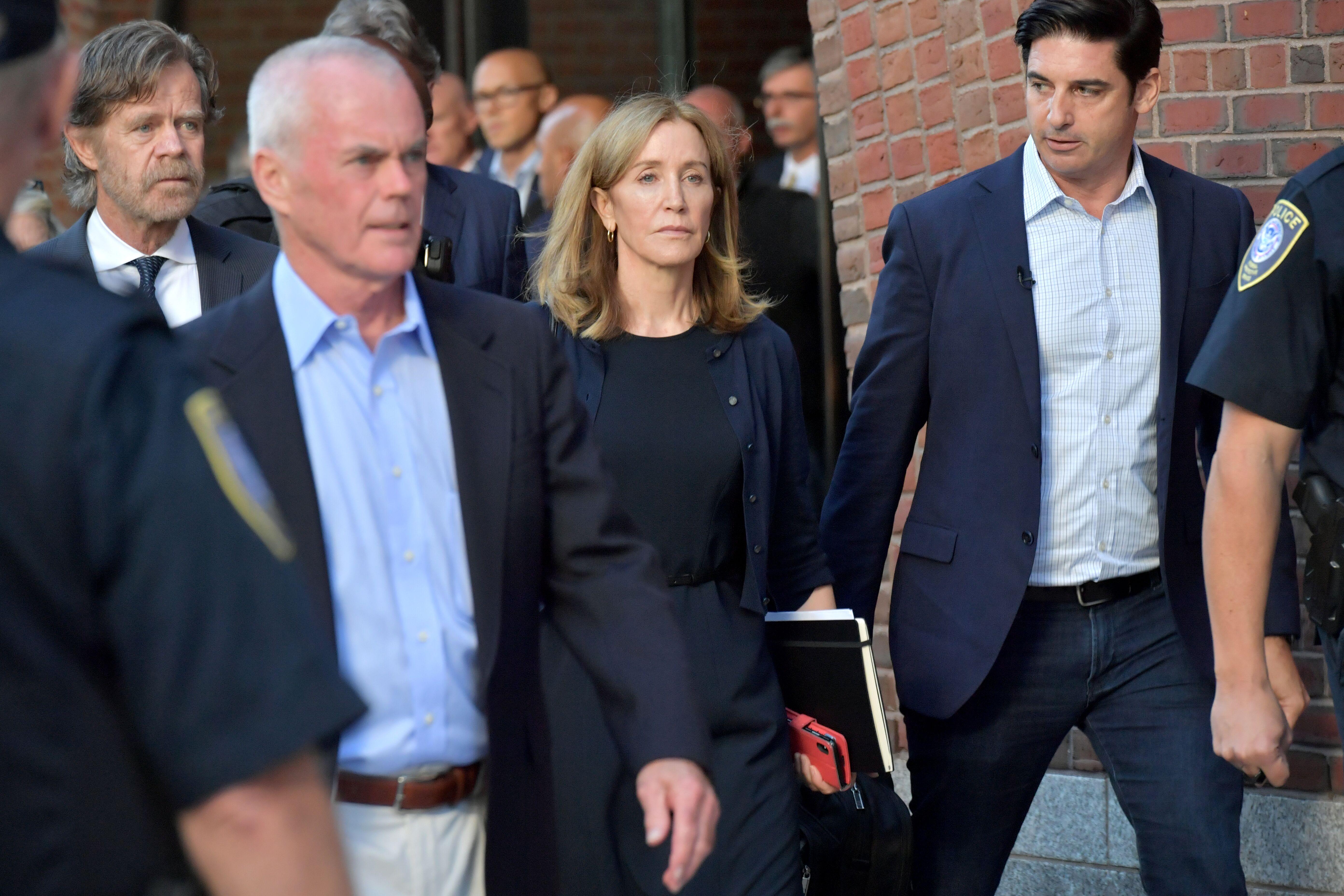 Felicity Huffman outside a Boston federal courthouse with her husband William H. Macy | Photo: Getty Images