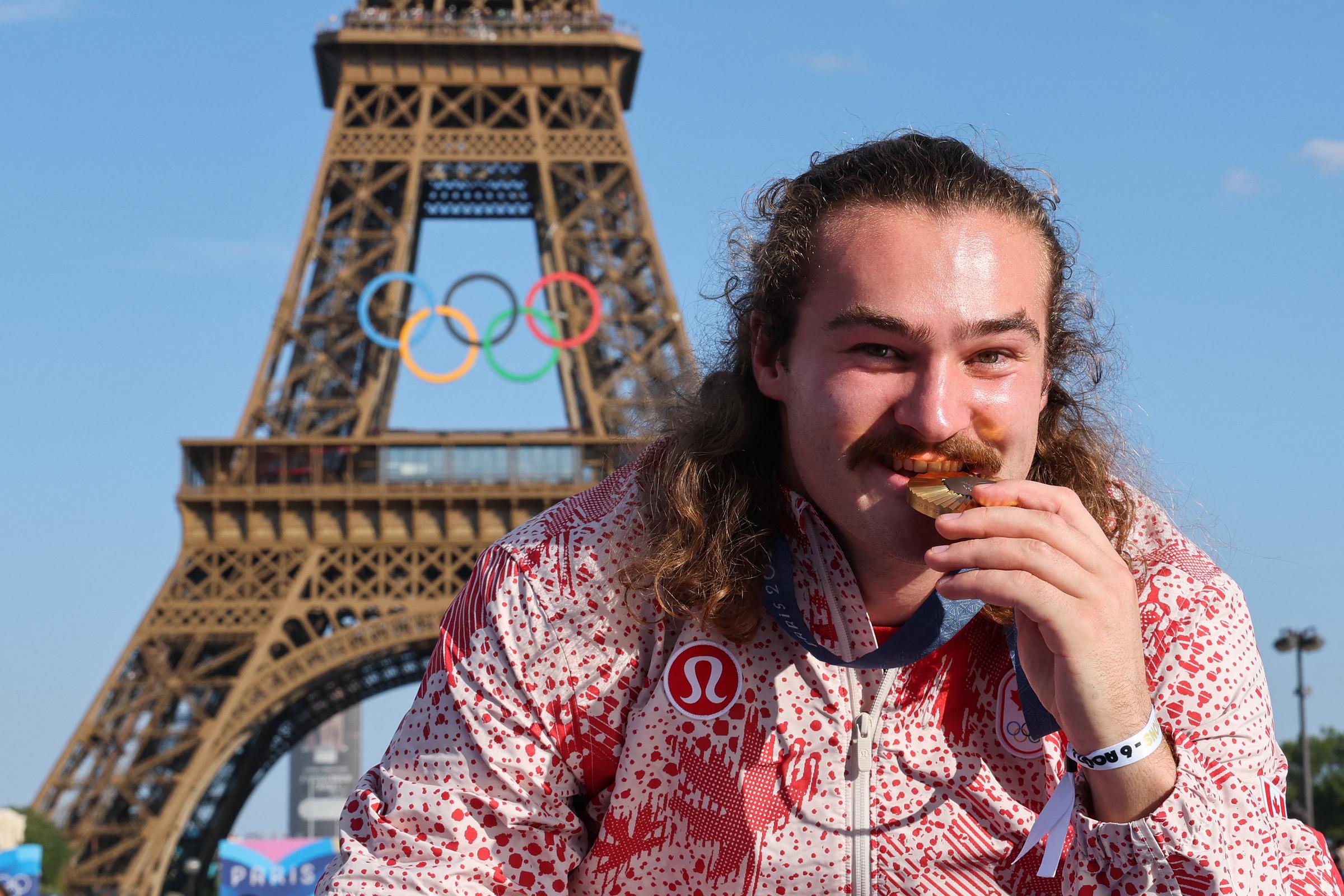 Ethan Katzberg poses with his medal on stage at the Champions Park at Trocadero during the Paris 2024 Olympic Games in Paris on August 6, 2024, with the Eiffel Tower visible in the background. | Source: Getty Images