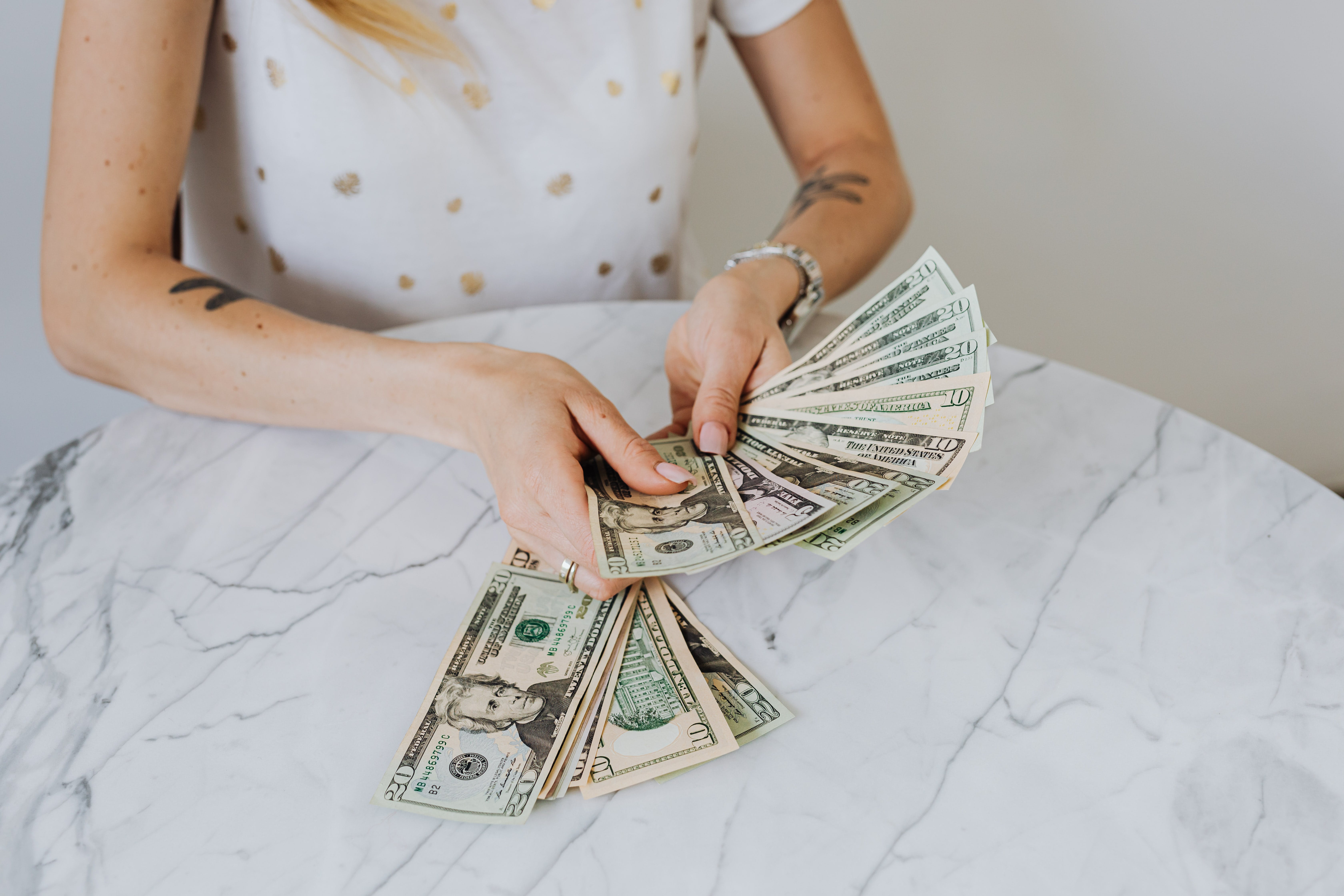 A person holding US dollar notes. | Source: Pexels