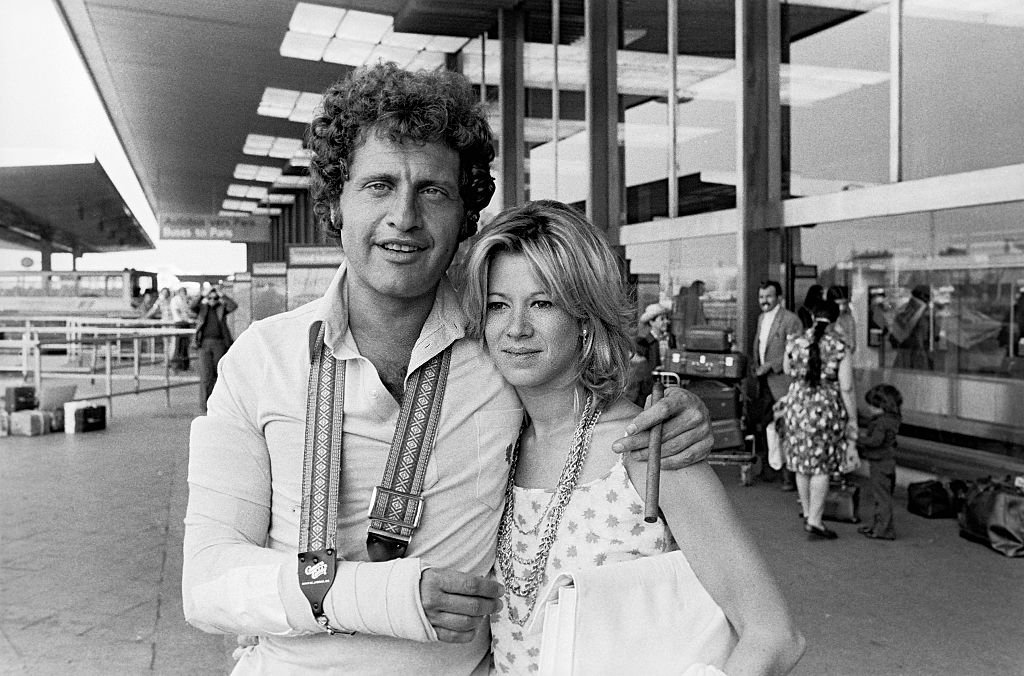 Joe Dassin chanteur français avec sa petite amie à l'aéroport d'Orly, le 04 juillet 1977. | Photo : Getty Images