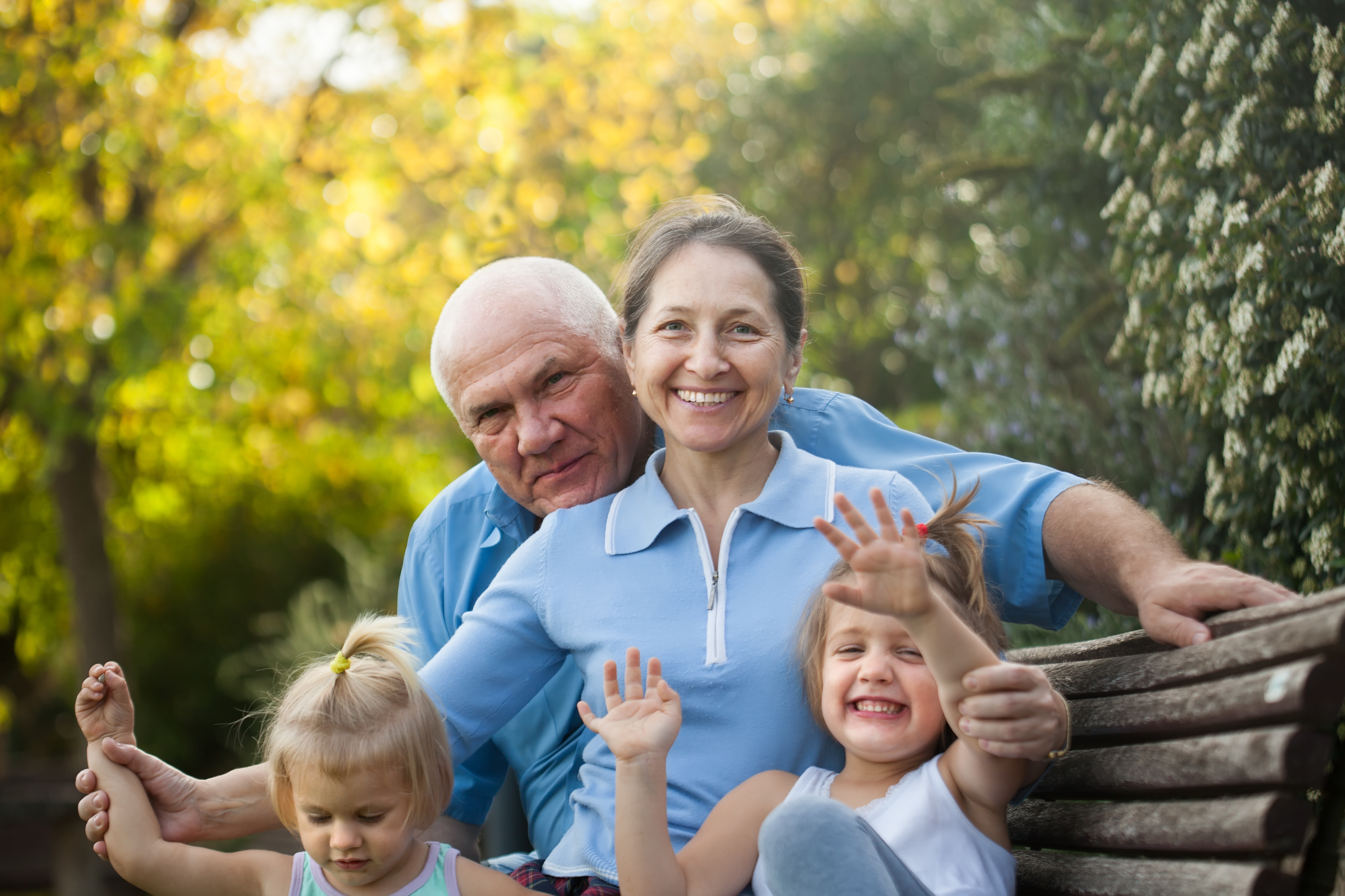 Senior couple sitting with their grandchildren in a park | Source: Shutterstock