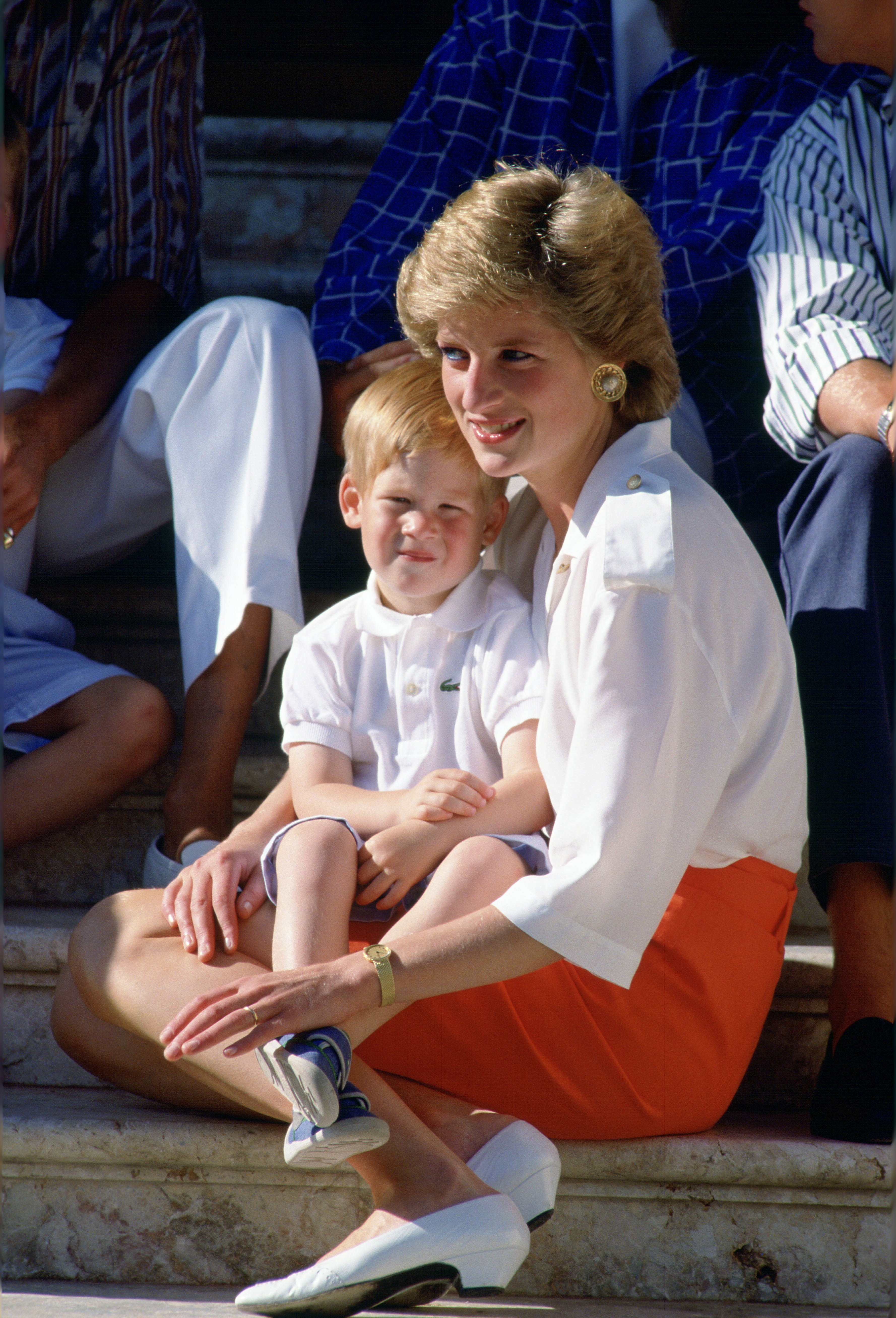 La princesa Diana fotografiada sentada en los escalones del Palacio de Marivent con su hijo, el príncipe Harry en una sesión de fotos durante sus vacaciones de verano. | Foto: Getty Images