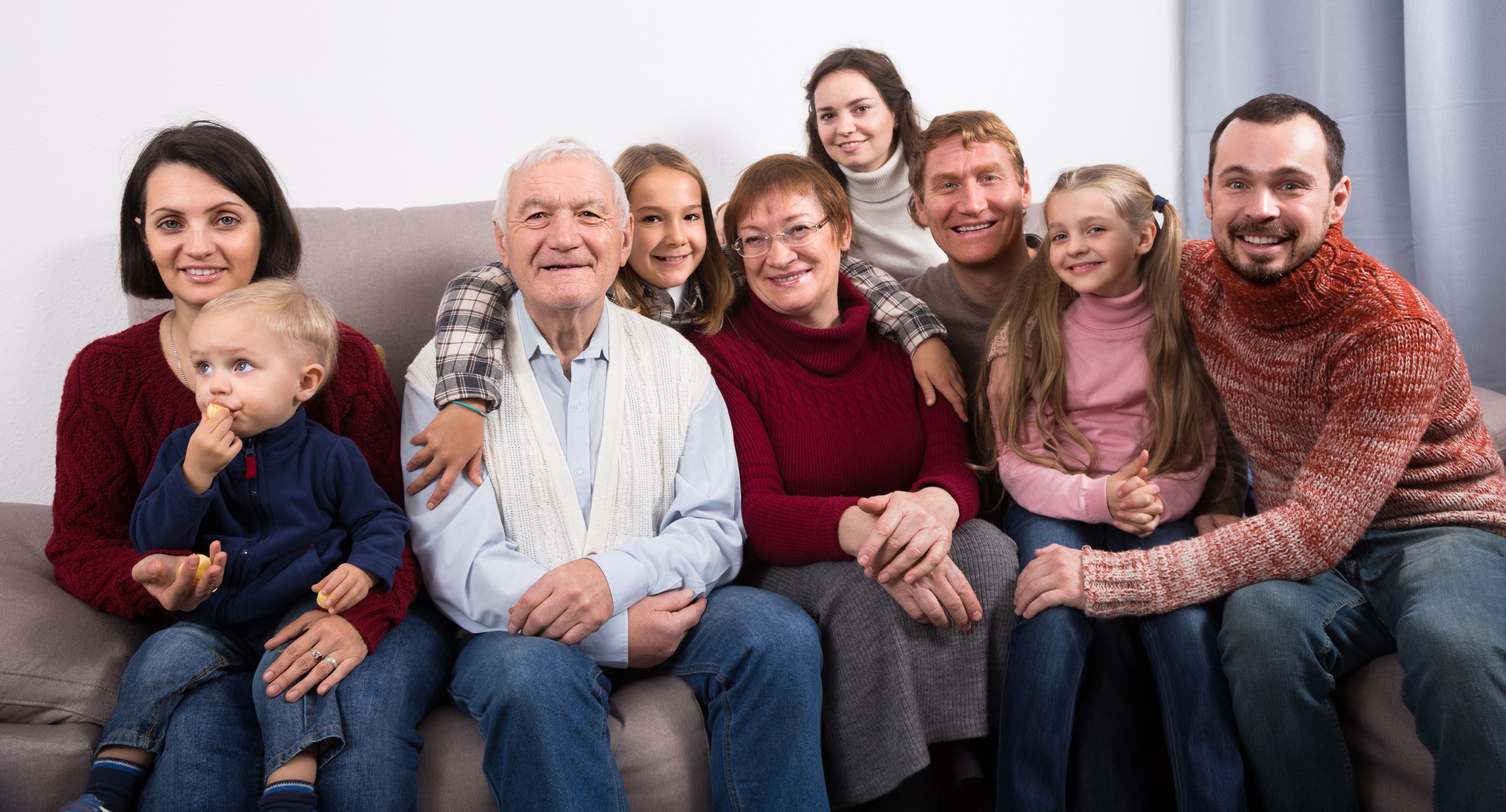 Hombre feliz rodeado por su familia extendida. | Fuente: Shutterstock