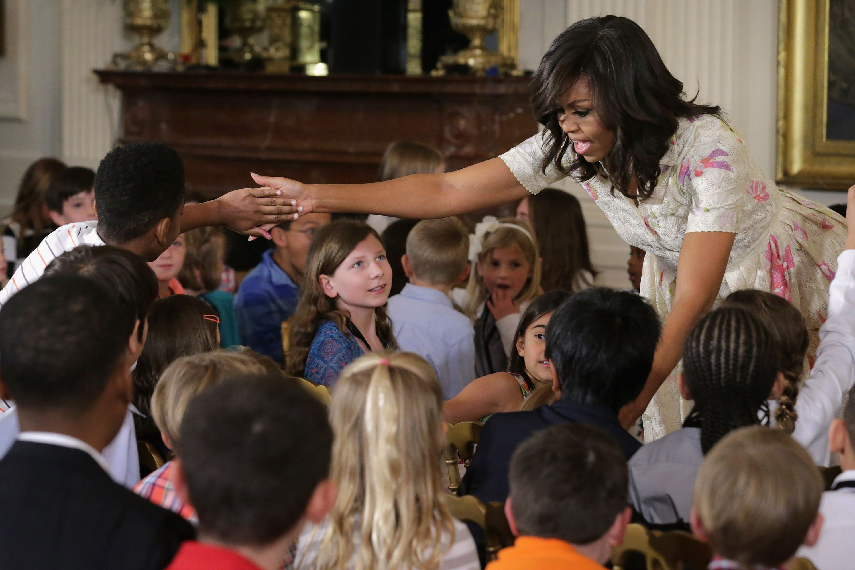 Michelle Obama gives hugs and high-fives to children for Take Our Daughters and Sons to Work Day in the East Room of the White House April 20, 2016 in Washington, DC. | Photo: Getty Images