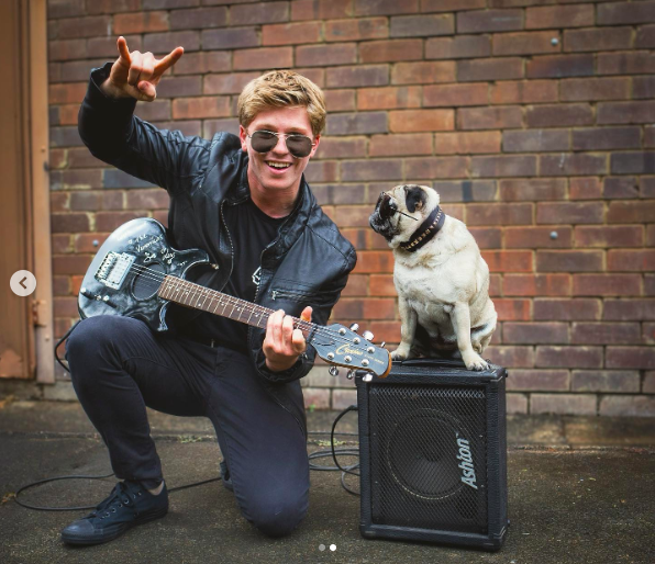 Robert Irwin posing in rockstar attire next to a pug, posted on October 31, 2020. | Source: Instagram/robertirwinphotography