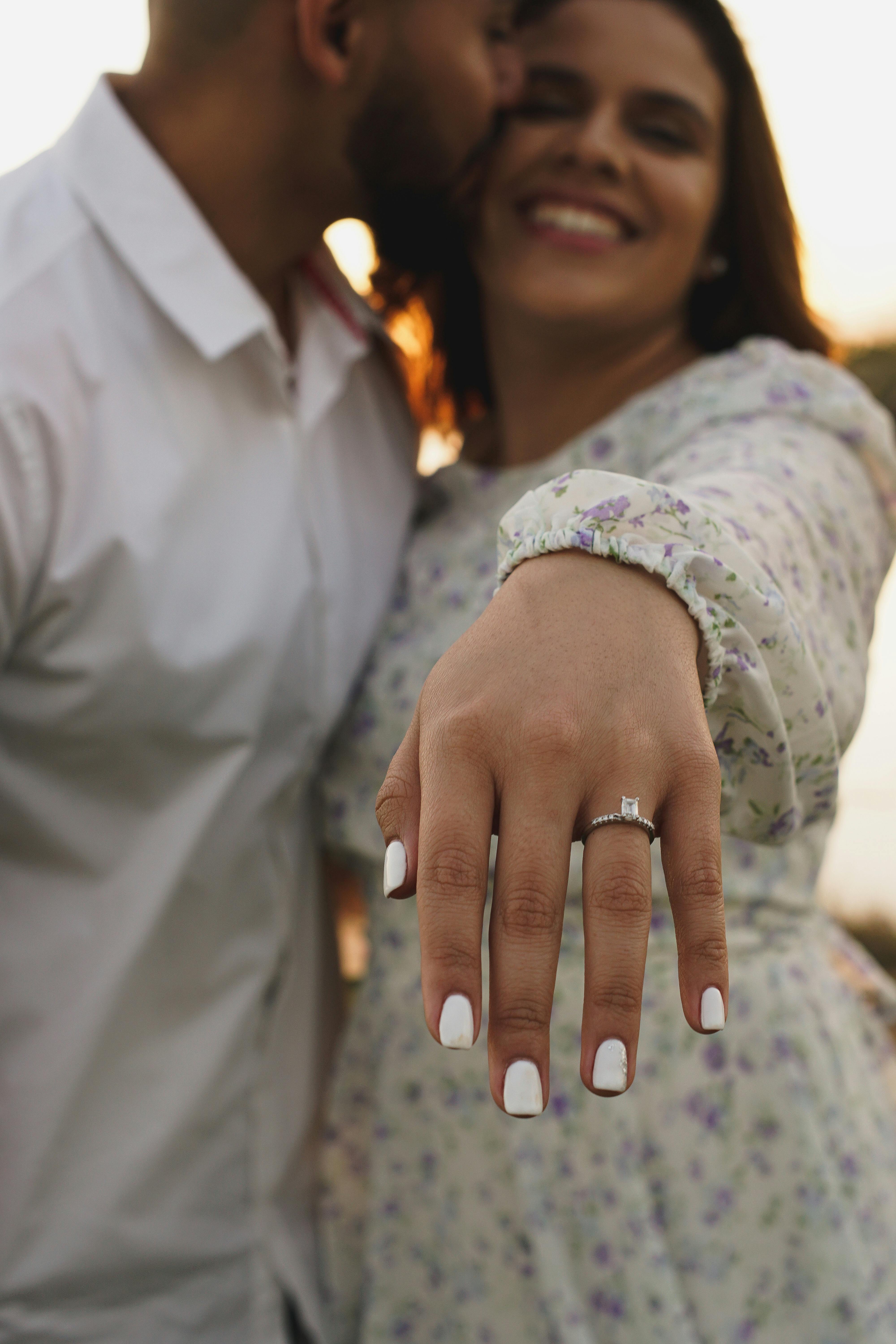 Happy couple with the bride showing off her wedding ring | Source: Pexels