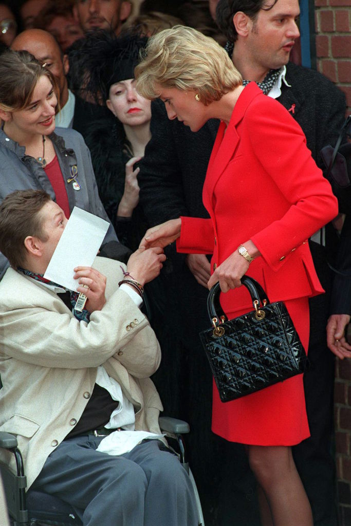 Princess Diana chats with a young disabled man as she arrives at the London Lighthouse, a center for people with AIDS in October 1996. | Source: Getty Images