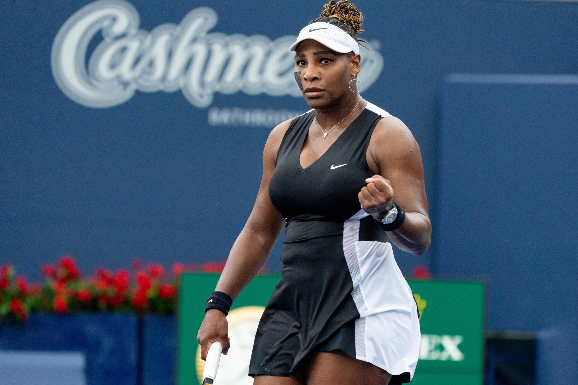 During the US Open in August 2022, Serena Williams celebrated after winning a point on the court. She wore a black Nike outfit with a sparkly skirt and matching wristbands.