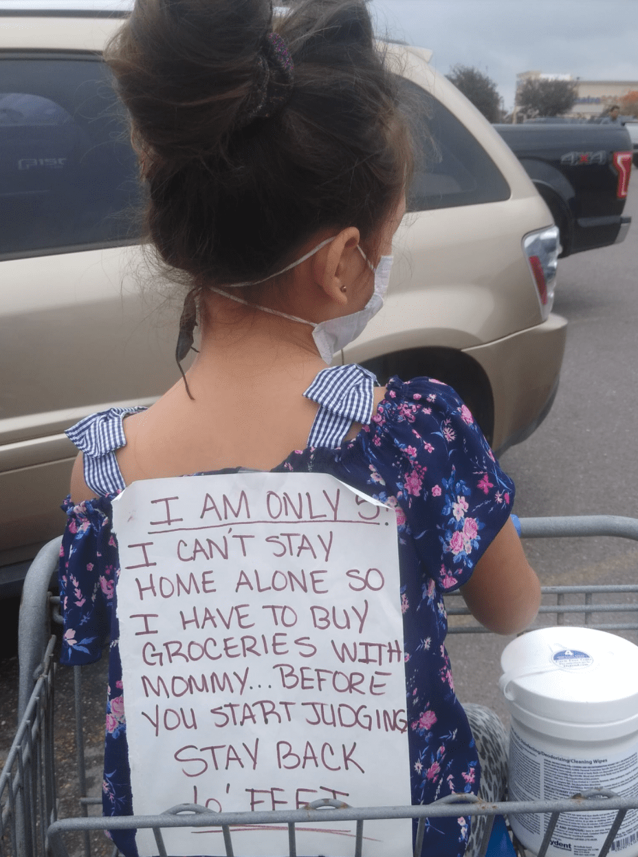 A single mother attached a sign to her daughter's back explaining why she came along to the supermarket | Photo: Facebook/LadyINKmaryJ 