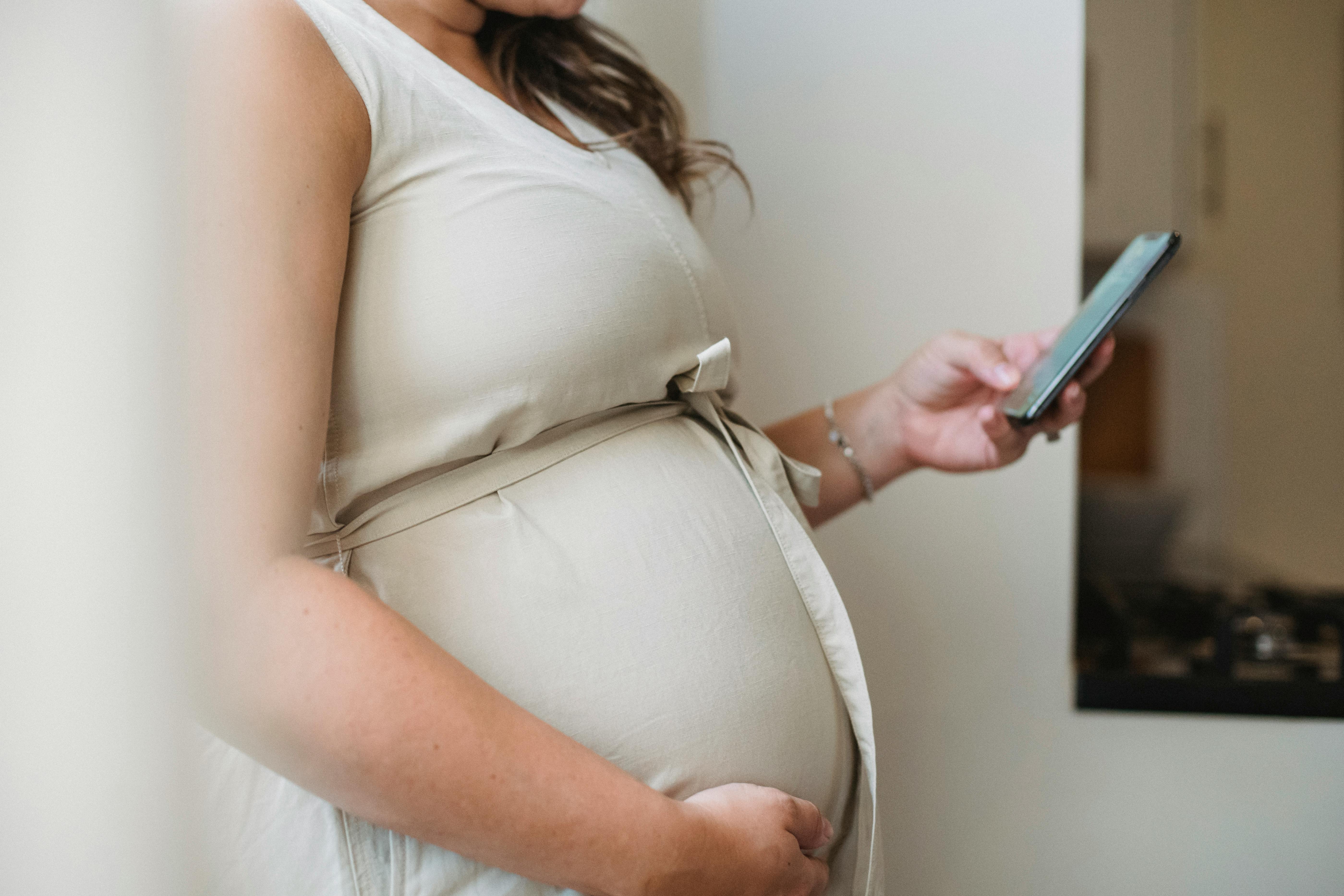 A pregnant woman using her phone | Source: Amina Filkins on Pexels