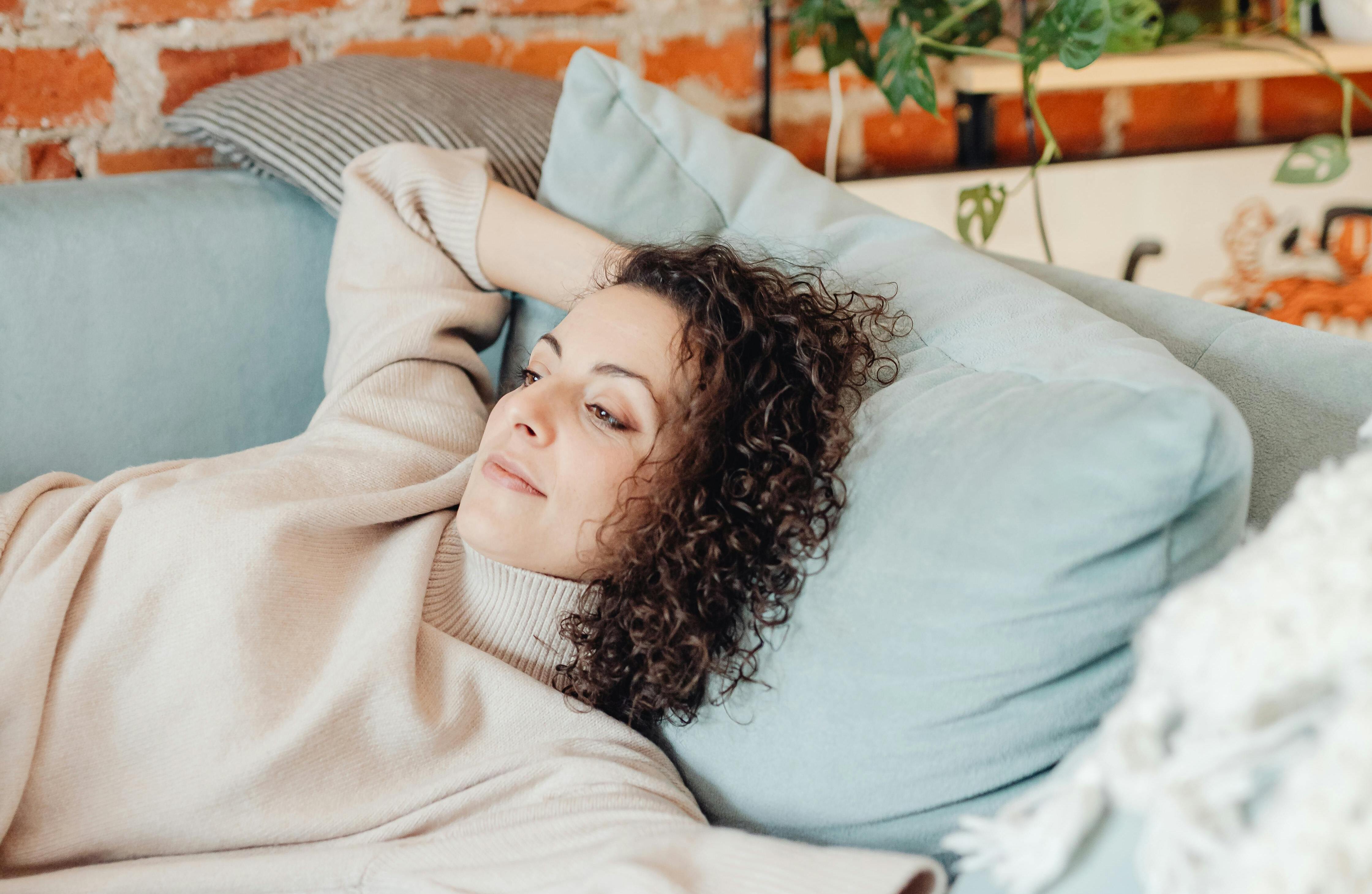 A woman lying on a couch | Source: Pexels