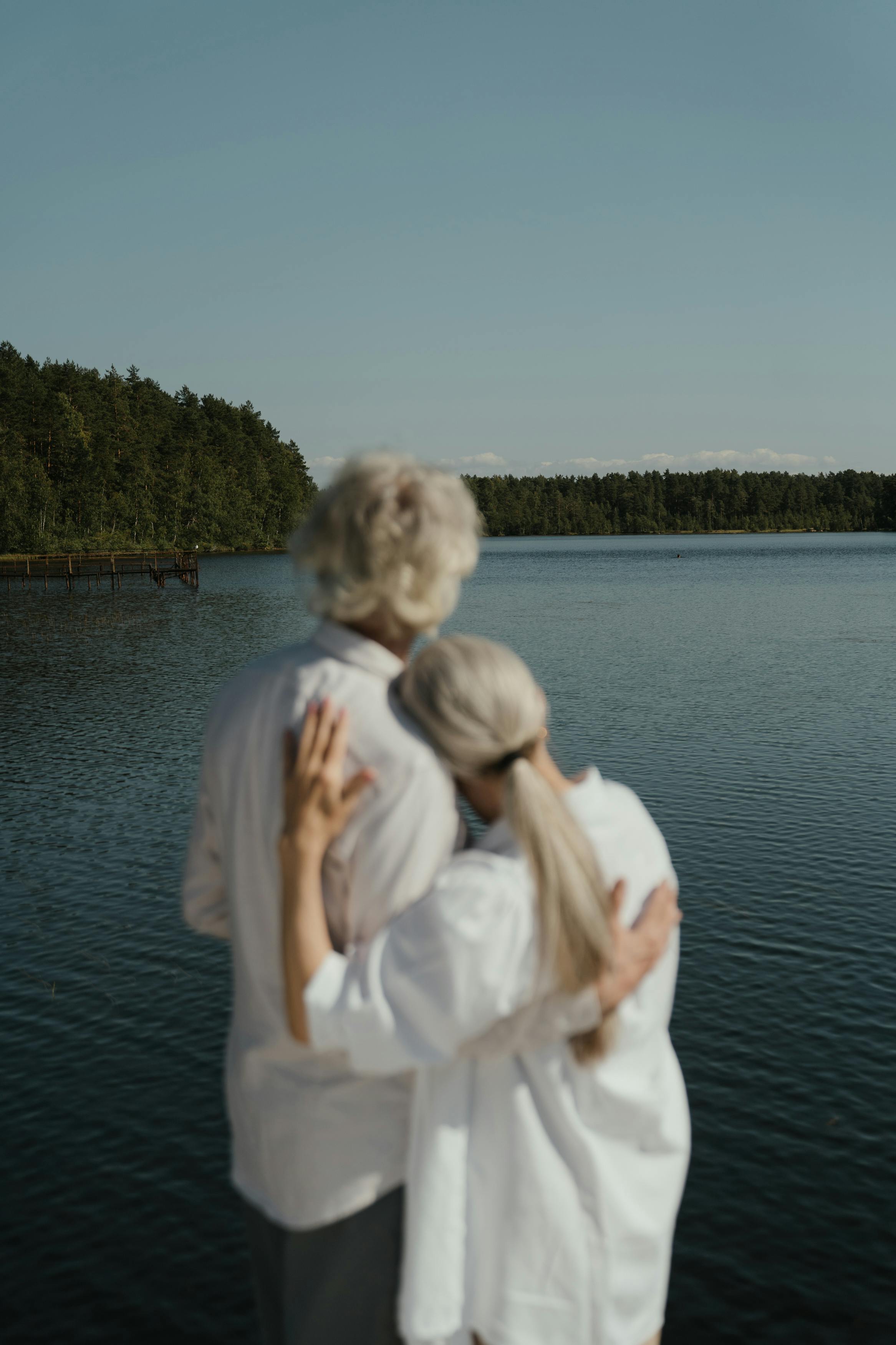 An older couple embracing while facing a lake | Source: Pexels