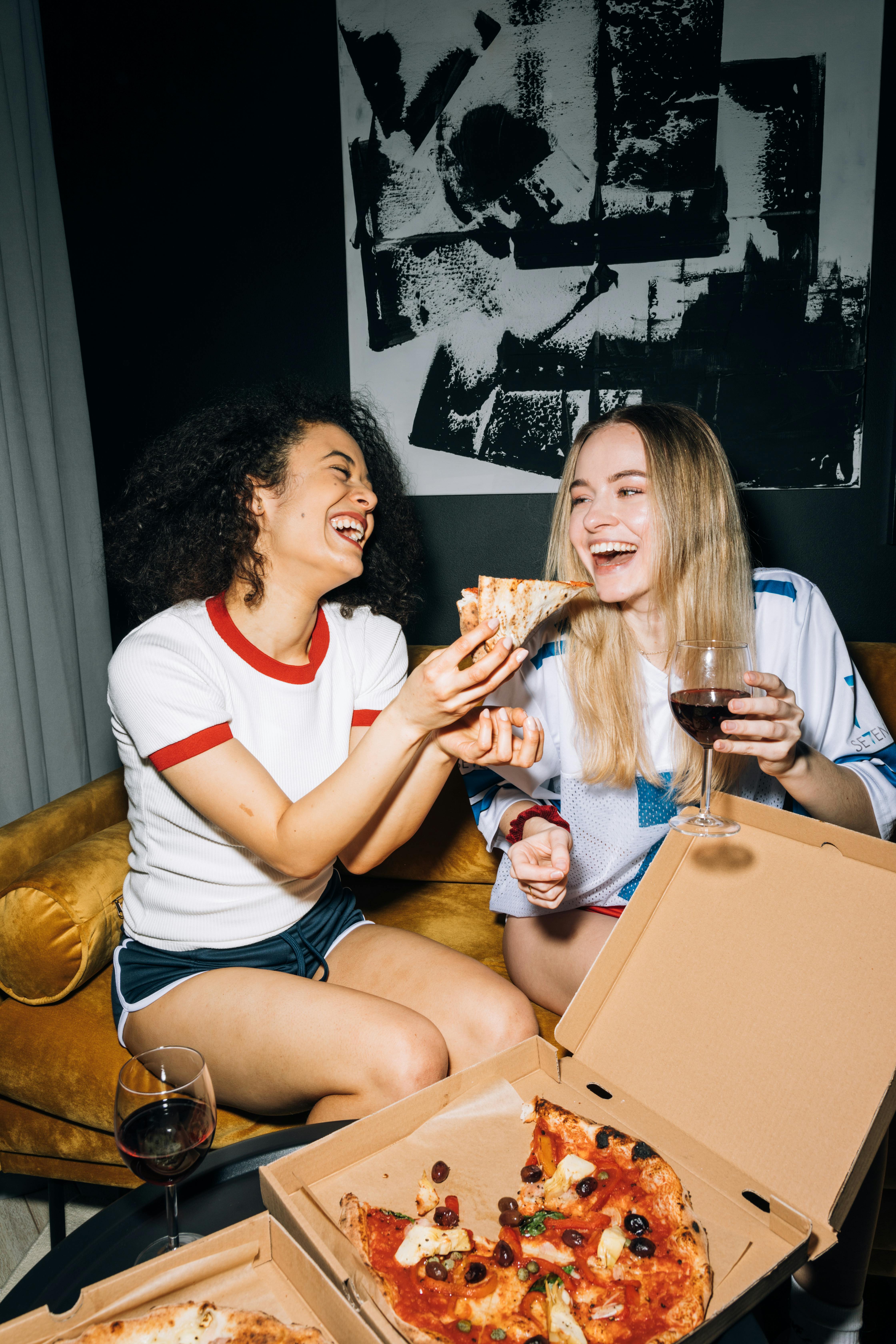 Women enjoying pizza and wine | Source: Pexels