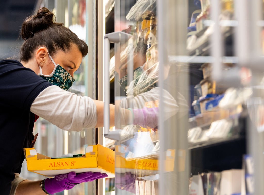 Une employée de supermarché masquée. | Photo : Getty Images Une employée de supermarché masquée. | Photo : Getty Images