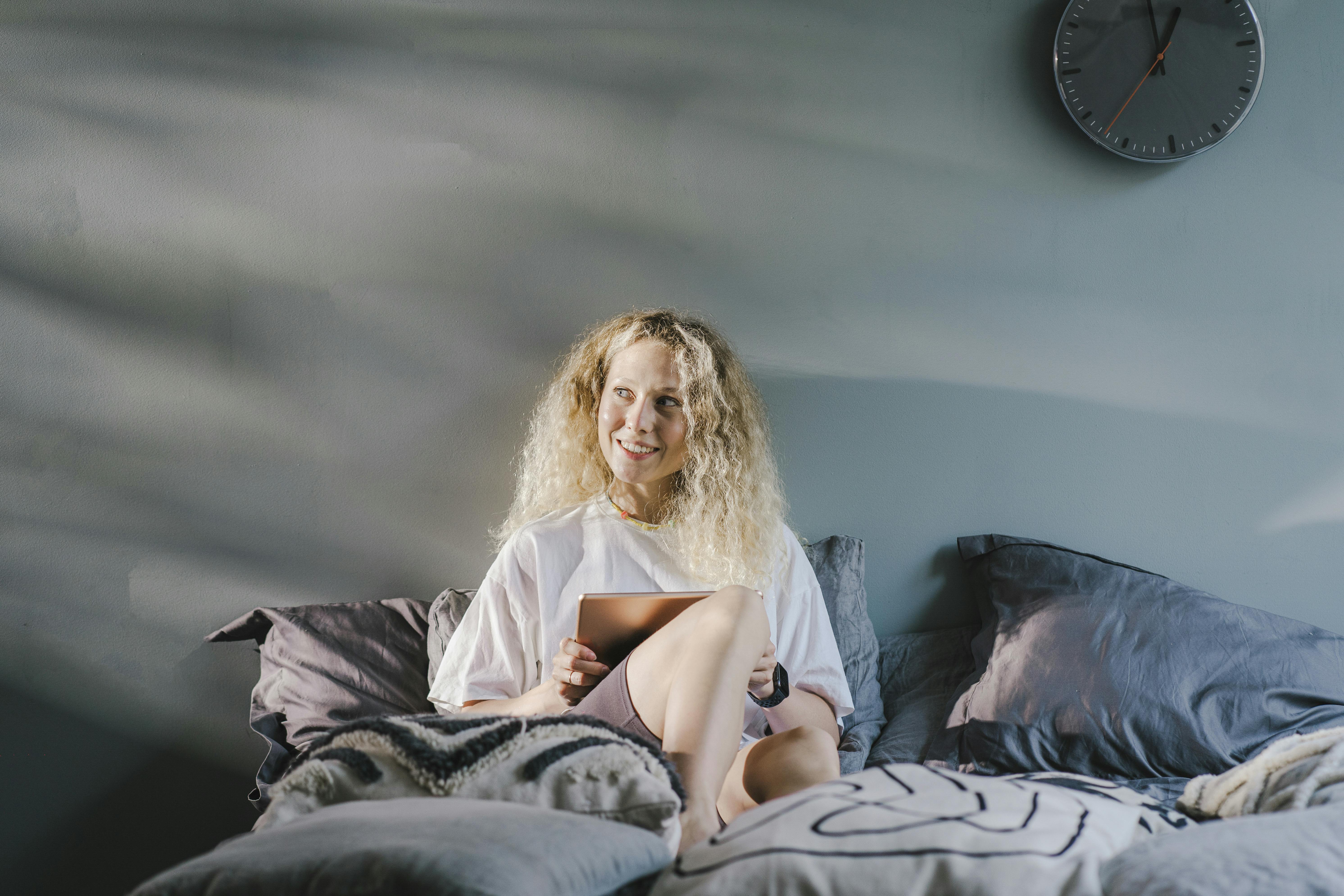 A woman smiling on her couch | Source: Pexels