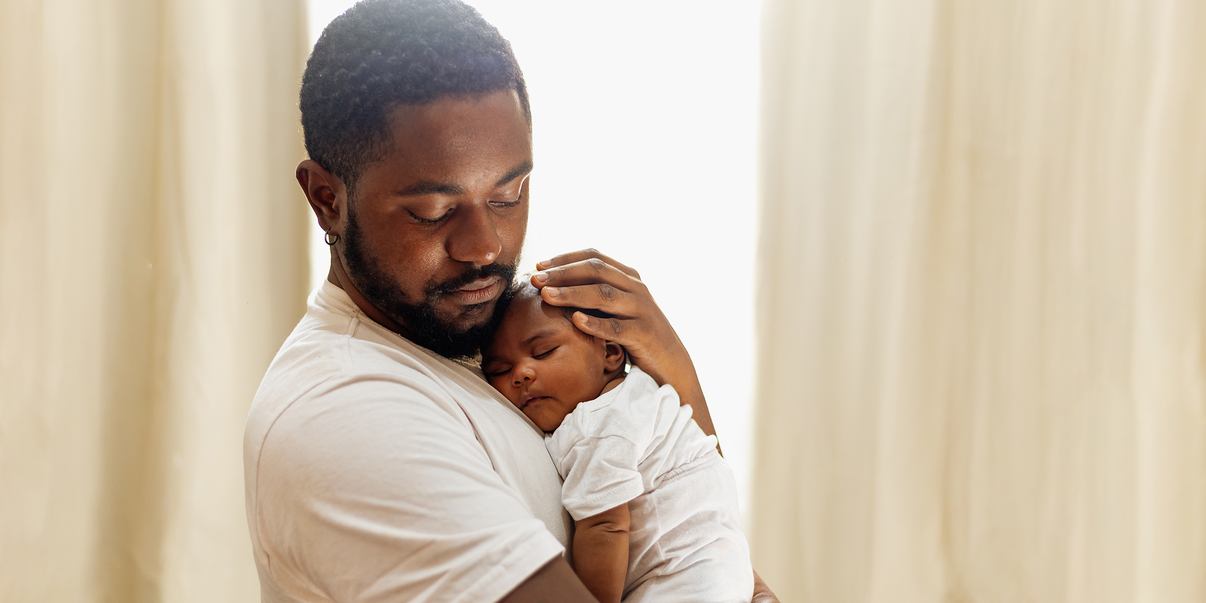A father holding his baby | Source: Shutterstock