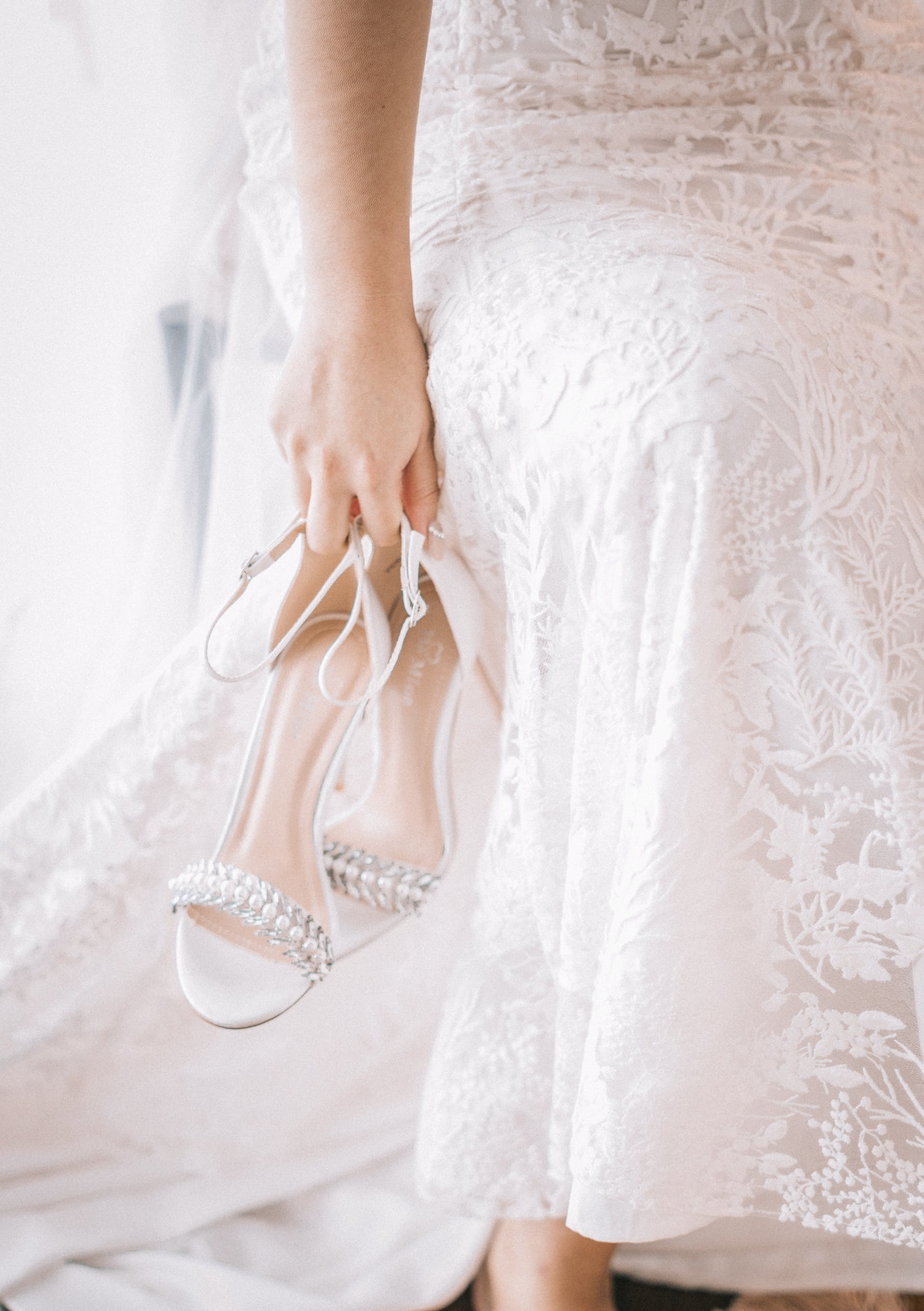 Bride holding her shoes | Source: Pexels